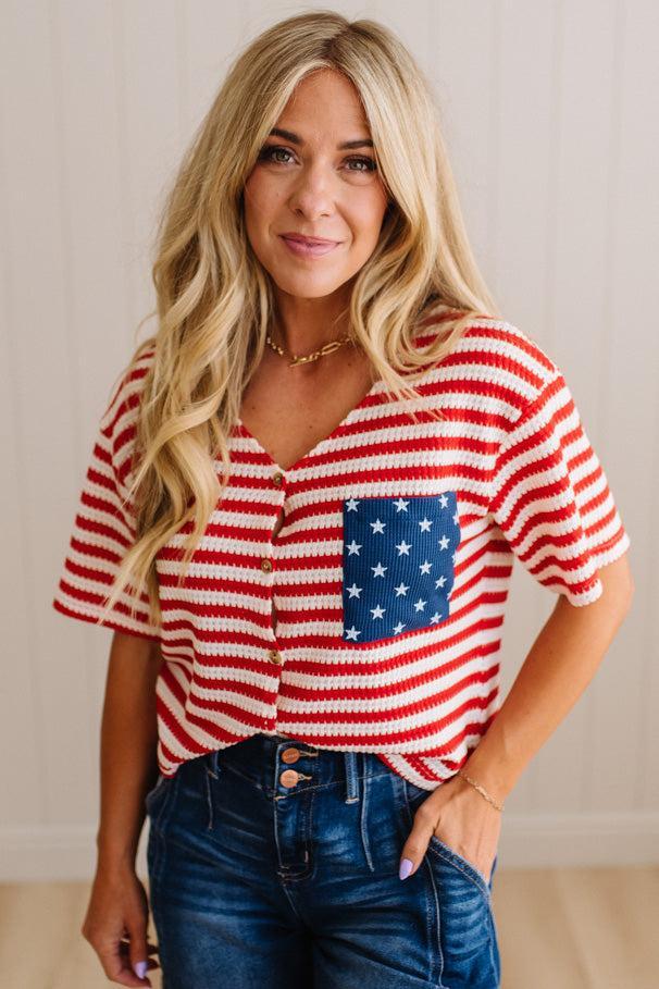 Woman wearing a red and white striped shirt with an American flag pocket.
