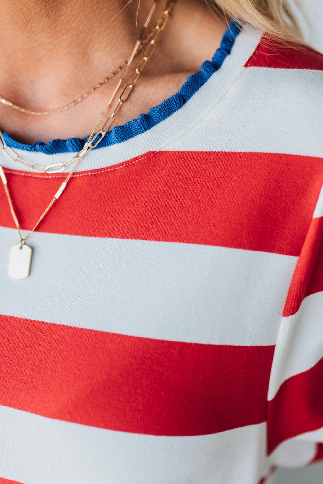Blonde Woman Wearing a Ruffle Ribbed Detail Stripe French Terry Mini Dress with bright red thick stripes.