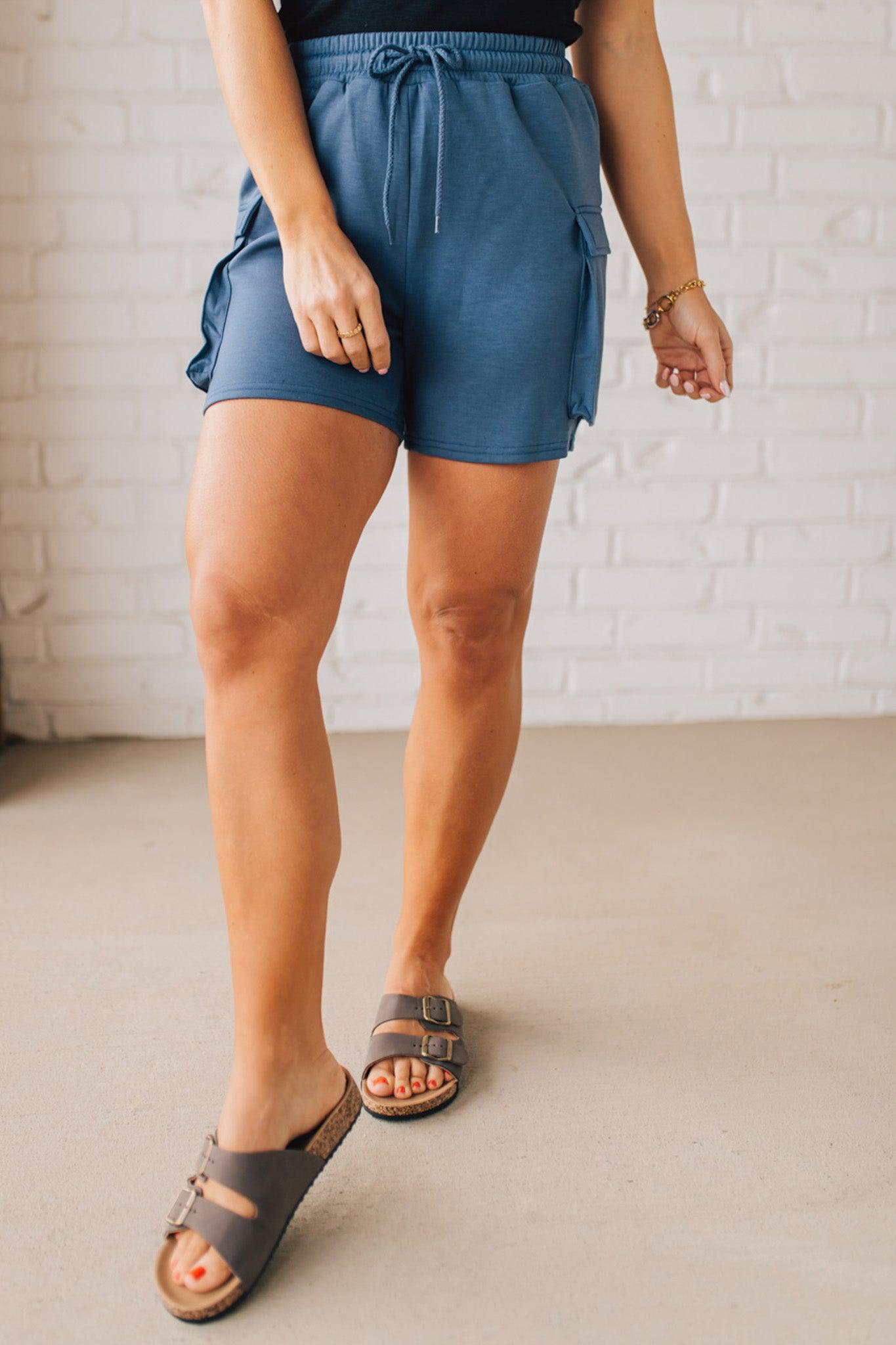 BLONDE WOMAN WEARING SCUBA THIGH POCKET SHORTS WITH ELASTIC WAIST & DRAWSTRING.