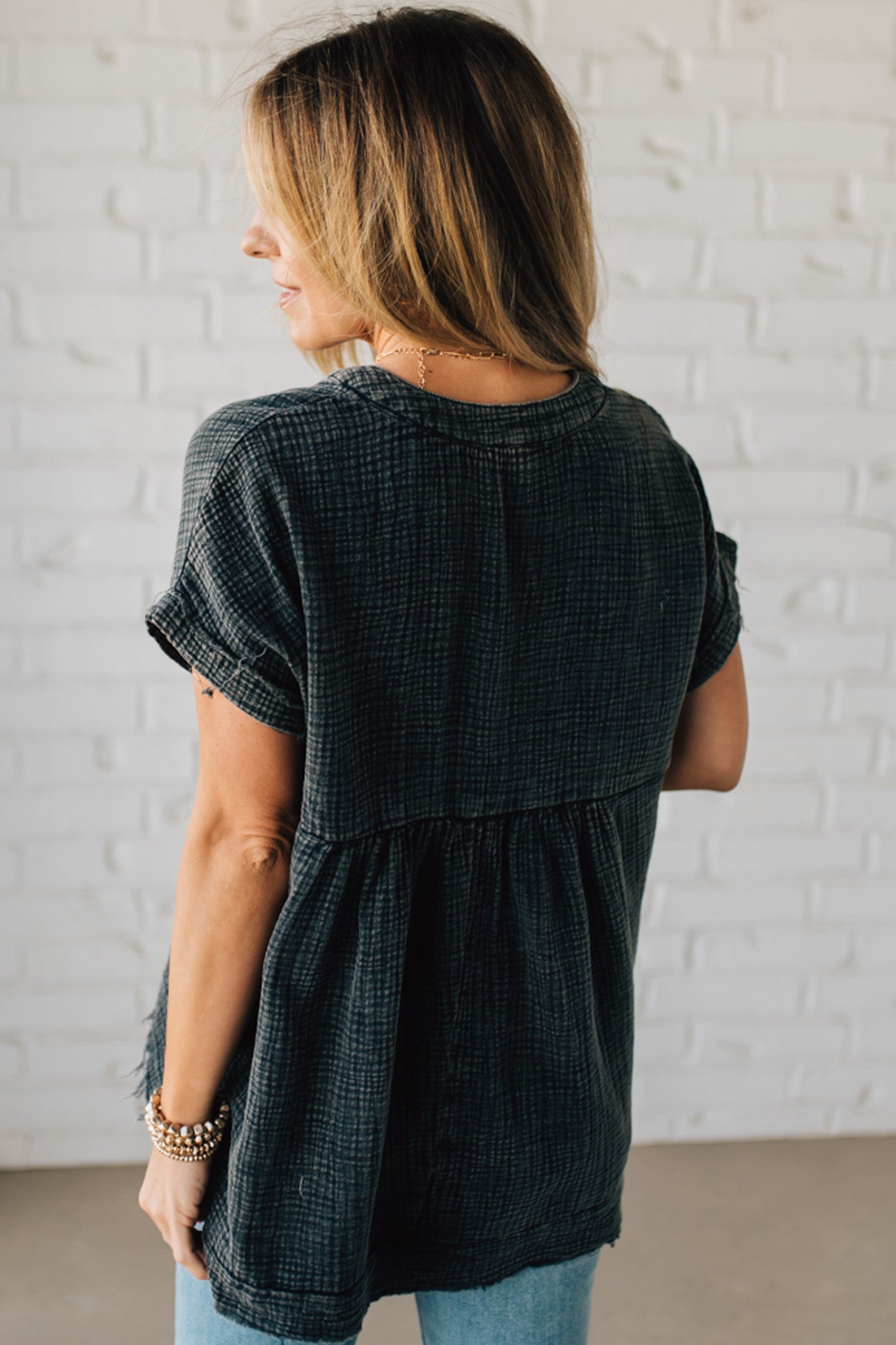 BLONDE WOMAN WEARING A WASHED DOUBLE GAUZE 3/4 BUTTON HENLEY NECK SHIRT.