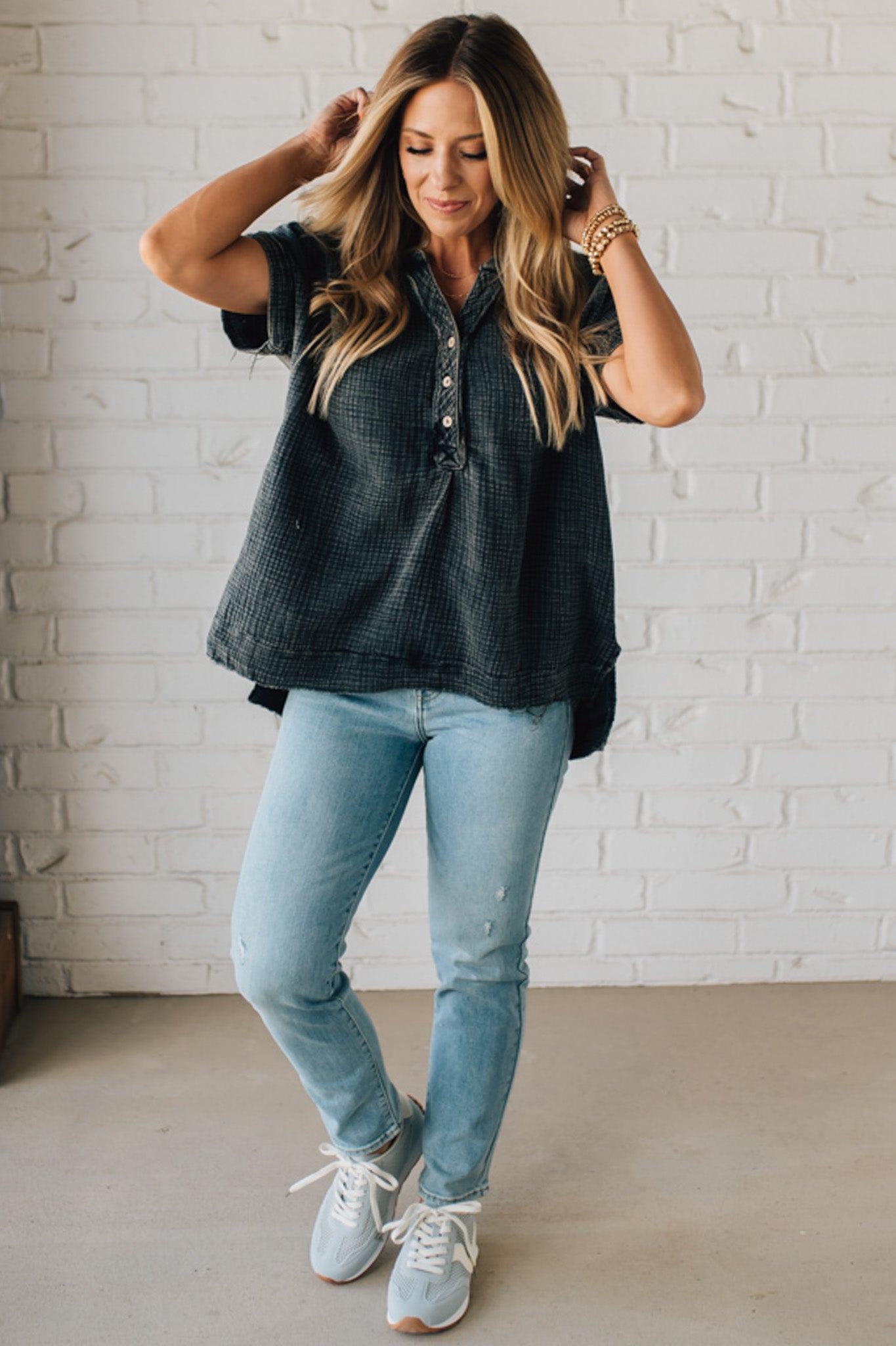 BLONDE WOMAN WEARING A WASHED DOUBLE GAUZE 3/4 BUTTON HENLEY NECK SHIRT.