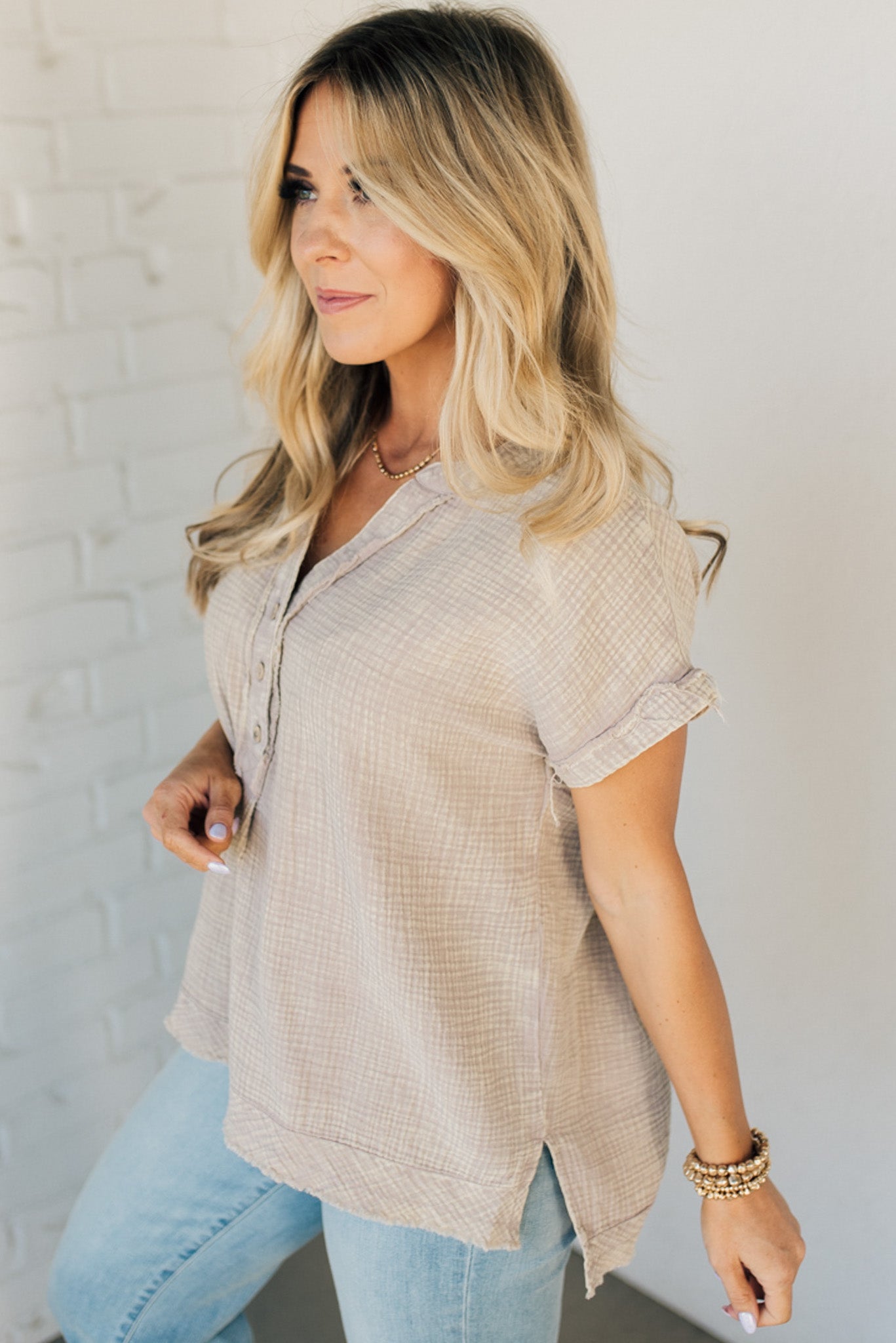 BLONDE WOMAN WEARING A WASHED DOUBLE GAUZE 3/4 BUTTON HENLEY NECK SHIRT.