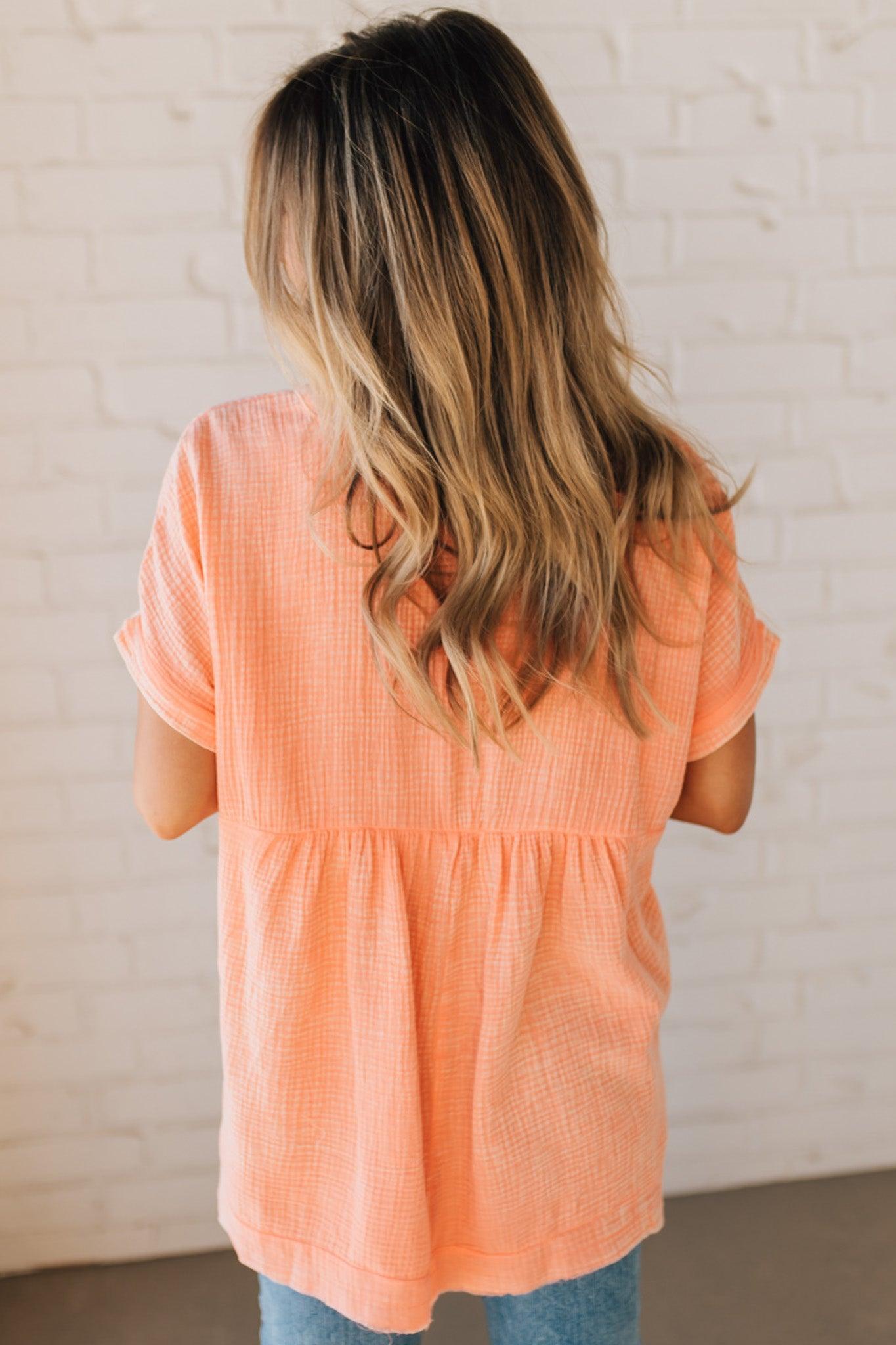 BLONDE WOMAN WEARING A WASHED DOUBLE GAUZE 3/4 BUTTON HENLEY NECK SHIRT.