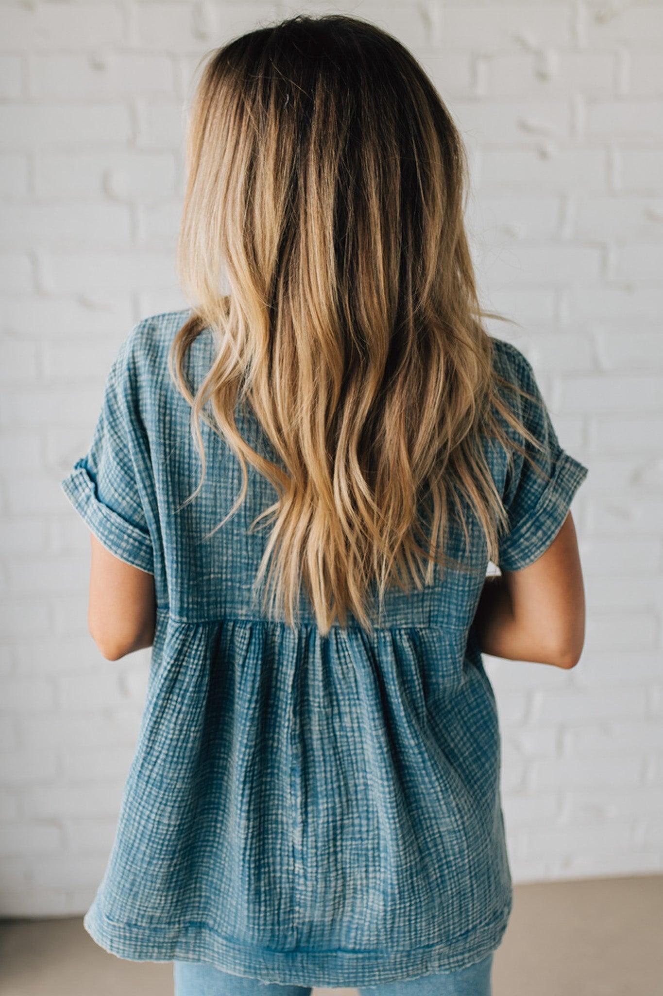 BLONDE WOMAN WEARING A WASHED DOUBLE GAUZE 3/4 BUTTON HENLEY NECK SHIRT.