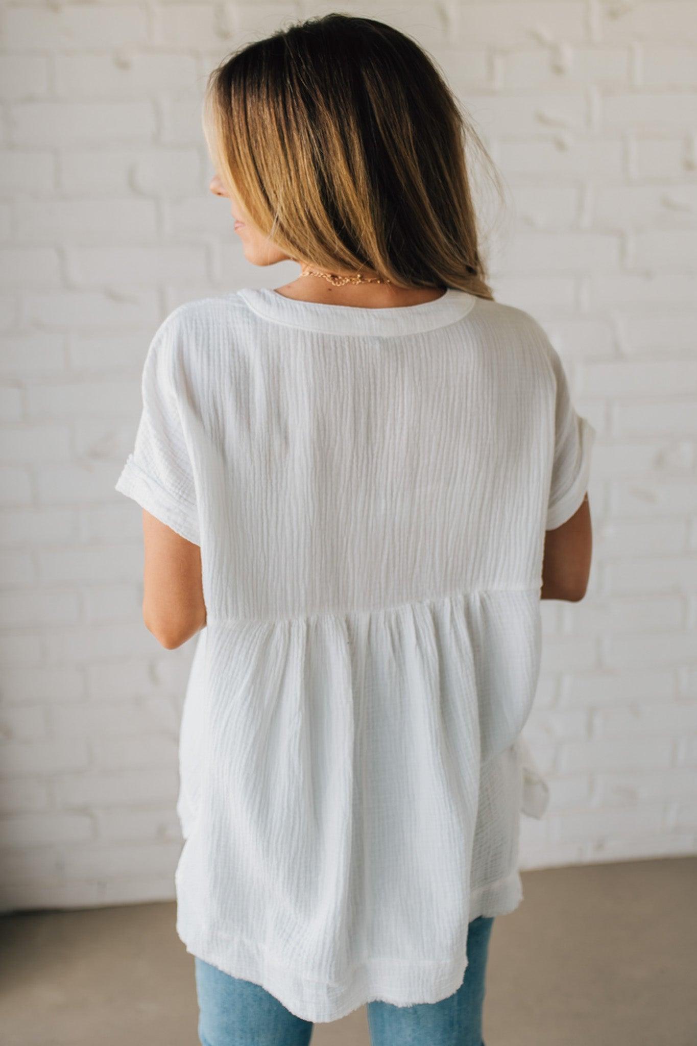 BLONDE WOMAN WEARING A WASHED DOUBLE GAUZE 3/4 BUTTON HENLEY NECK SHIRT.
