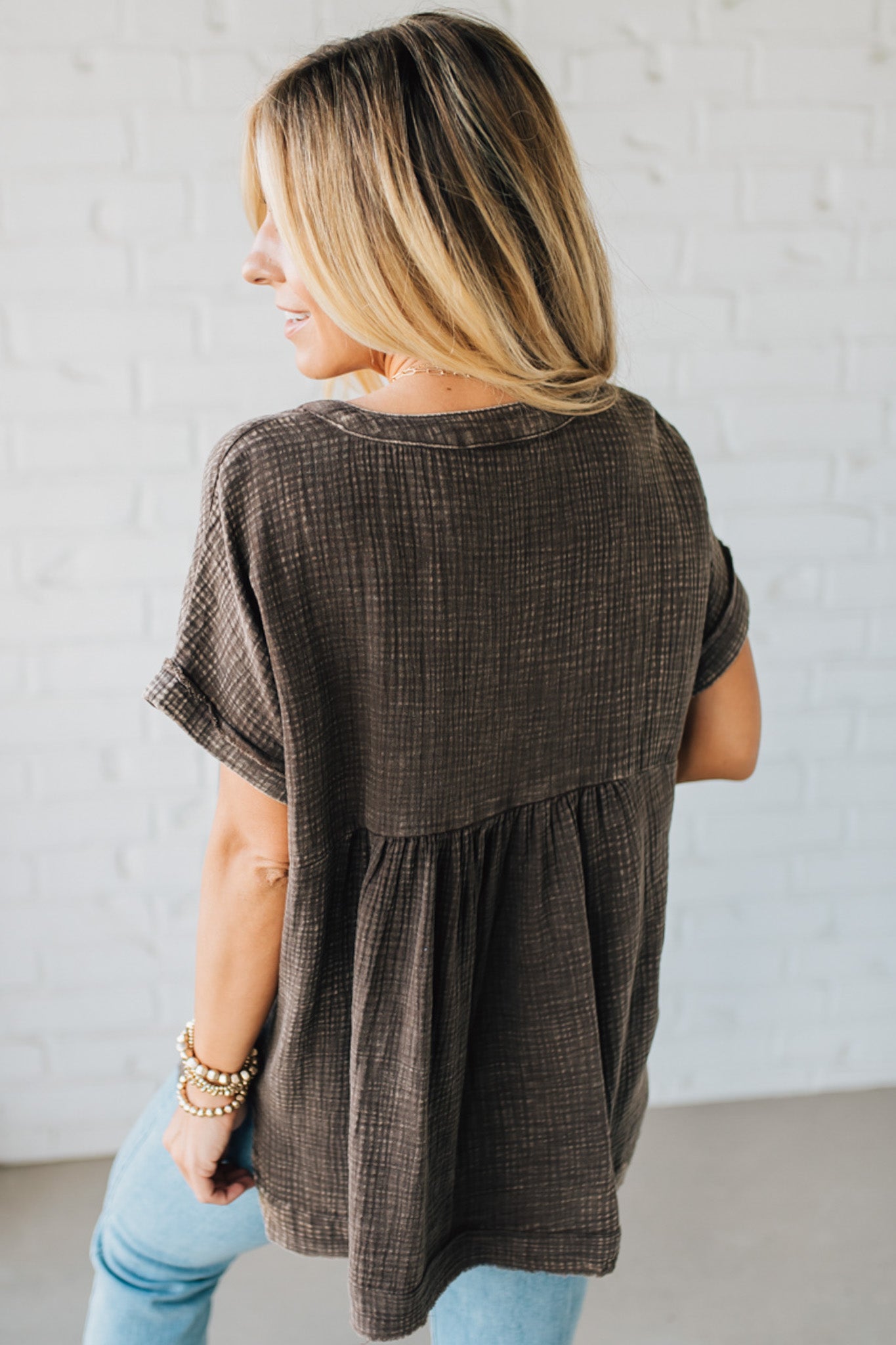 BLONDE WOMAN WEARING A WASHED DOUBLE GAUZE 3/4 BUTTON HENLEY NECK SHIRT.
