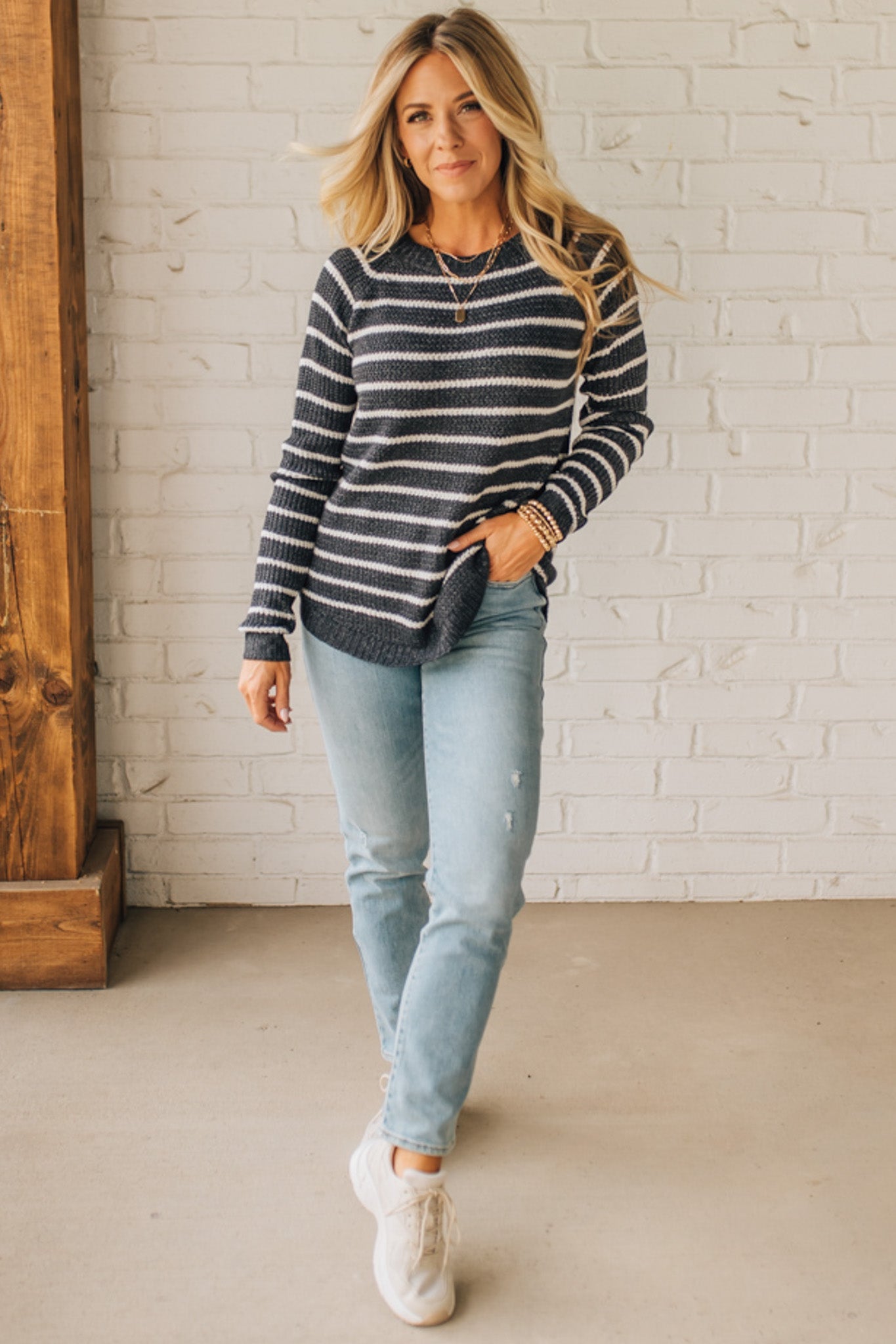 BLONDE WOMAN WEARING A CREW NECK, LONG RAGLAN SLEEVE, CURVED HEM, MINI WAFFLE STRIPED PULLOVER SWEATER