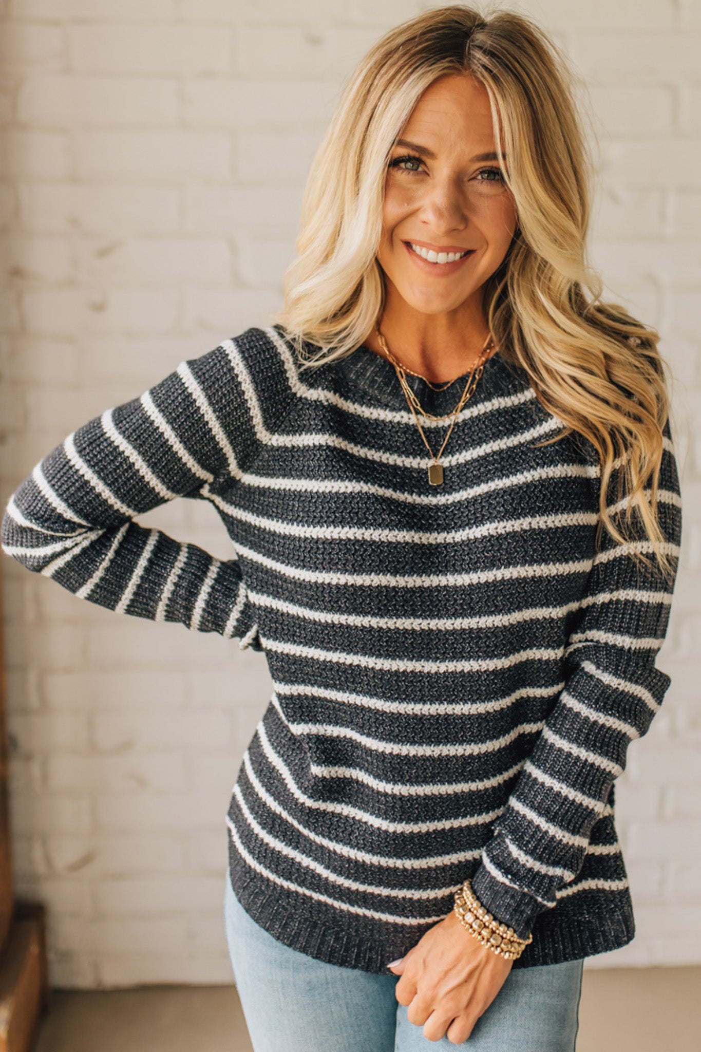 BLONDE WOMAN WEARING A CREW NECK, LONG RAGLAN SLEEVE, CURVED HEM, MINI WAFFLE STRIPED PULLOVER SWEATER