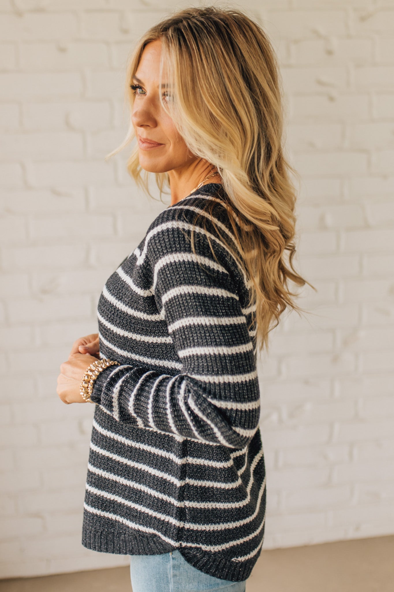 BLONDE WOMAN WEARING A CREW NECK, LONG RAGLAN SLEEVE, CURVED HEM, MINI WAFFLE STRIPED PULLOVER SWEATER