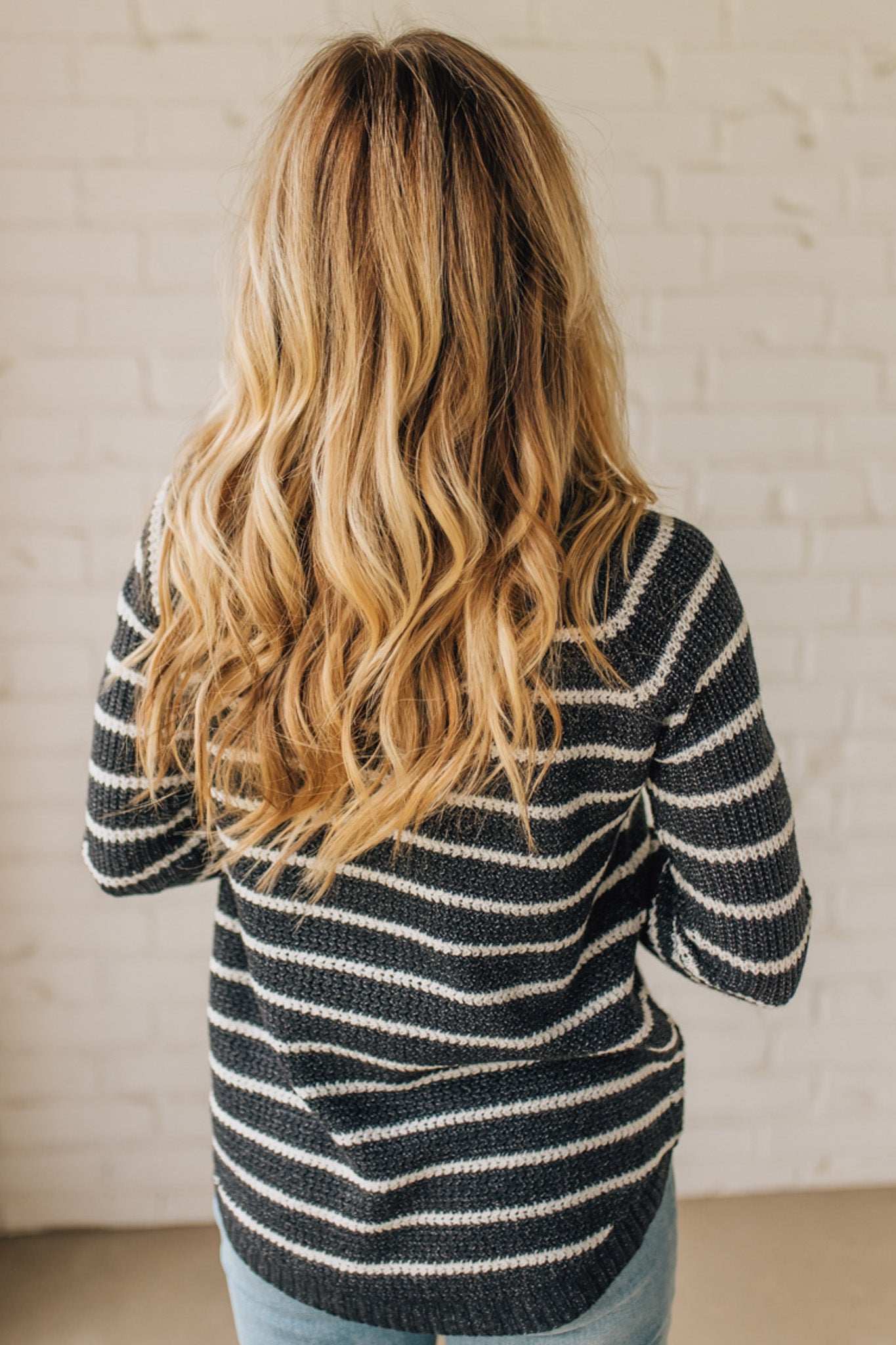 BLONDE WOMAN WEARING A CREW NECK, LONG RAGLAN SLEEVE, CURVED HEM, MINI WAFFLE STRIPED PULLOVER SWEATER