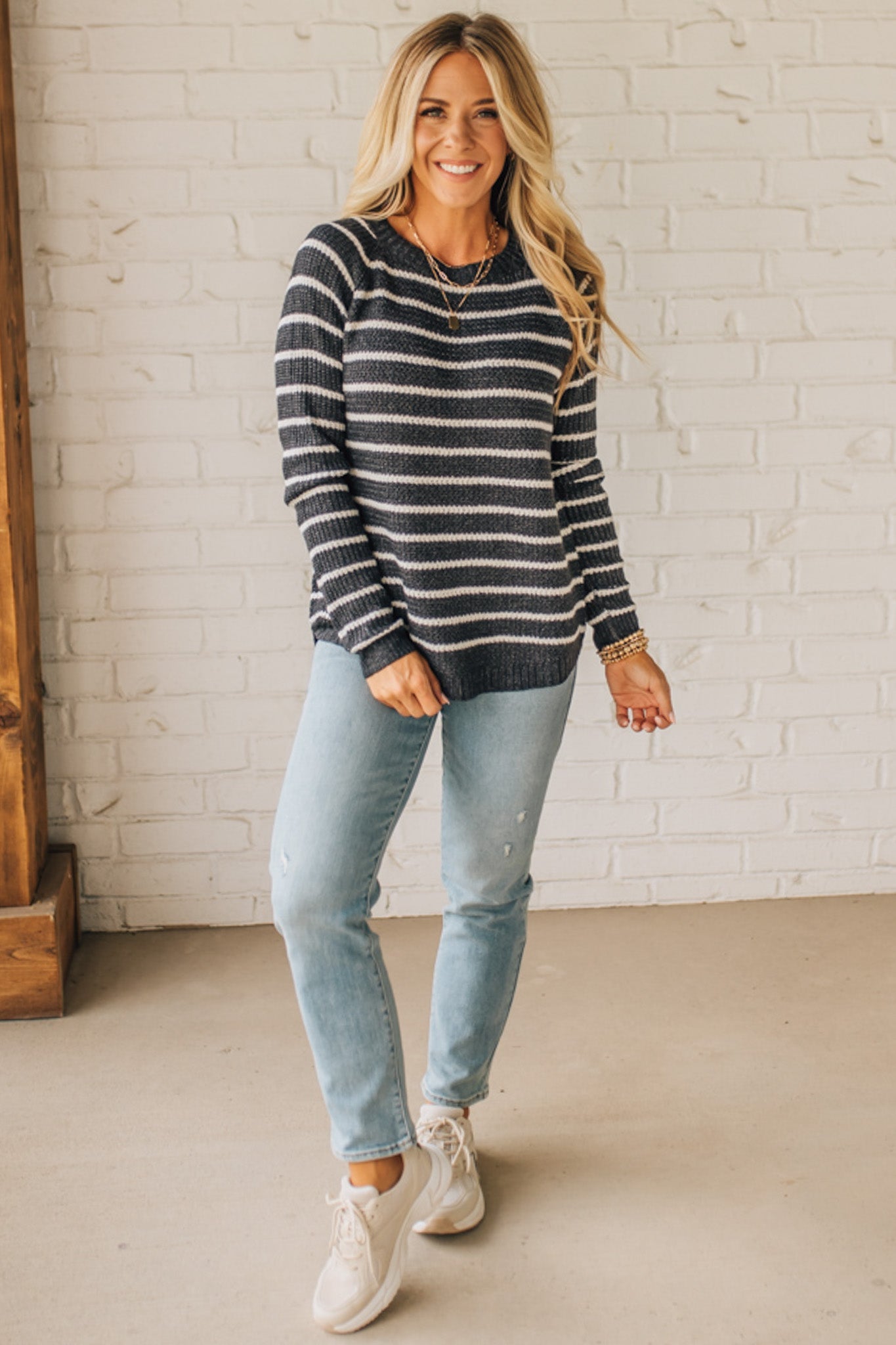 BLONDE WOMAN WEARING A CREW NECK, LONG RAGLAN SLEEVE, CURVED HEM, MINI WAFFLE STRIPED PULLOVER SWEATER