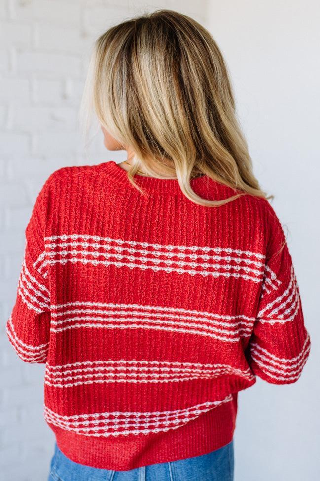 Person wearing a red and white striped sweater against a plain background