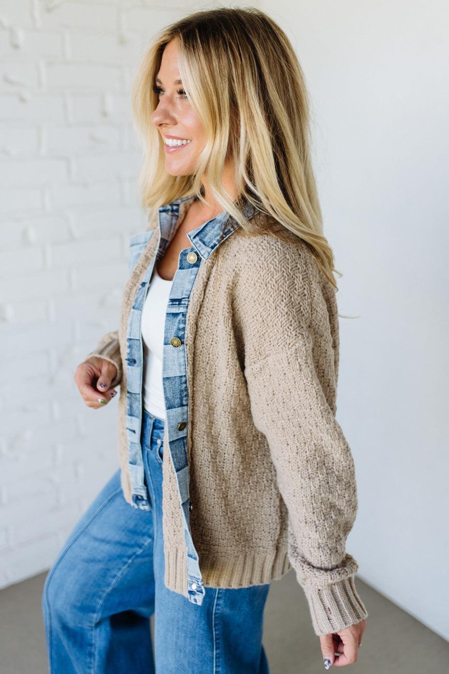 Woman wearing a beige cardigan with a denim trim with a white background