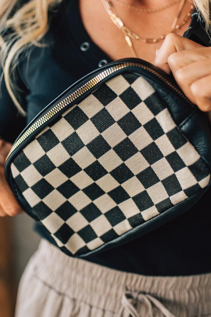 Person holding a black and white checkered bag
