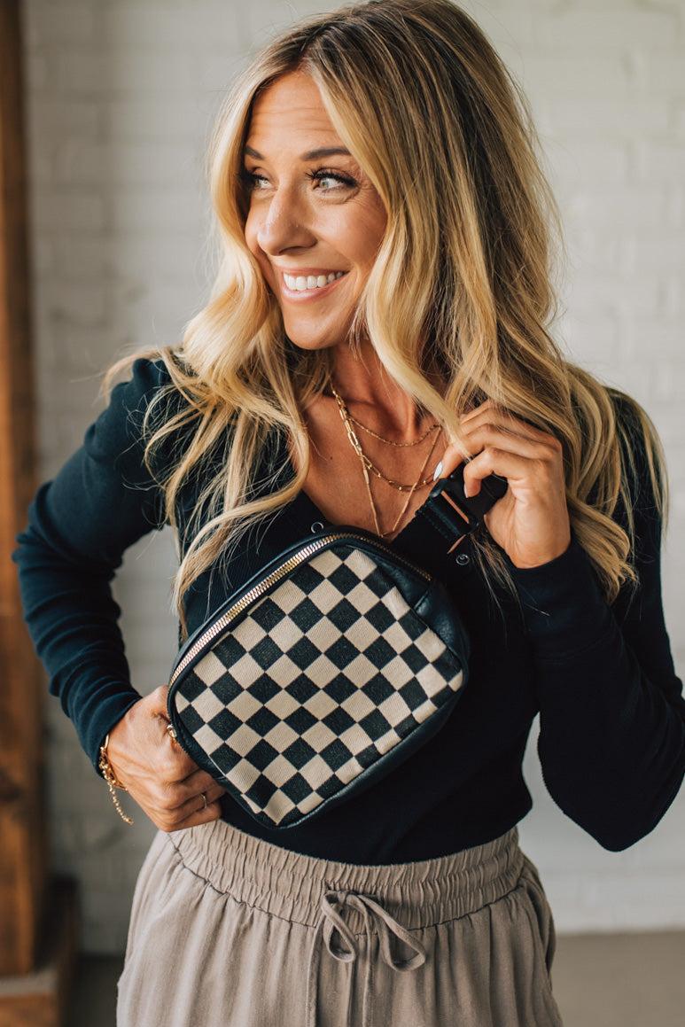 Woman holding a checkered bag indoors
