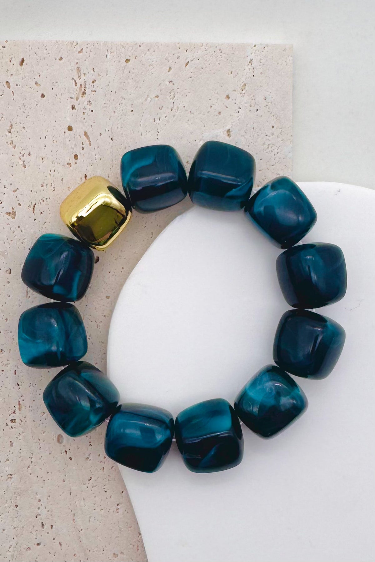 Dark Cyan bead bracelet with a gold accent bead shown on a woman's wrist in her pocket.