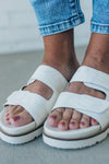 woman wearing white double strap slides with an tone on tone embroidered detail