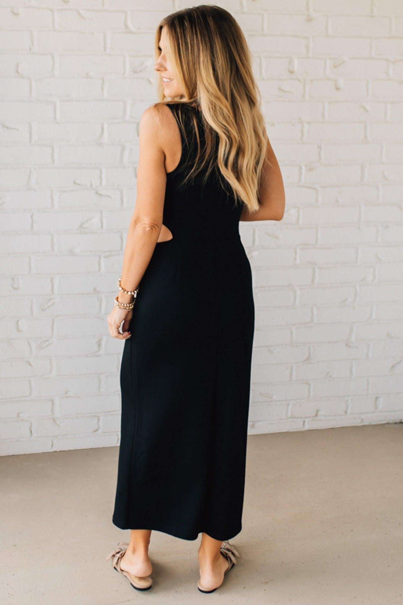 Blonde Woman Wearing a Black Maxi Length Pencil Dress with Side Cut Out on the Left.