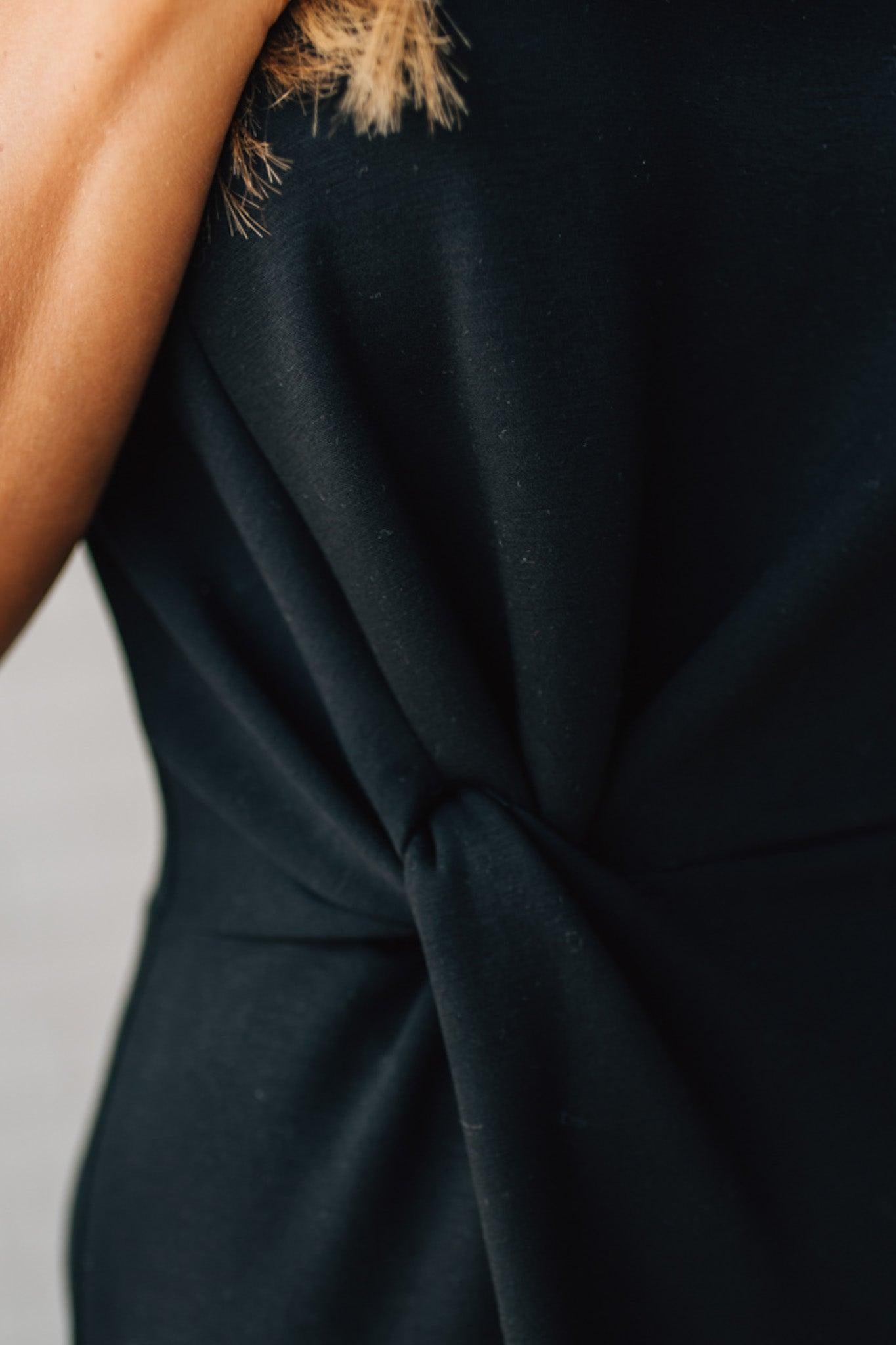 Blonde Woman Wearing a Black Maxi Length Pencil Dress with Side Cut Out on the Left.