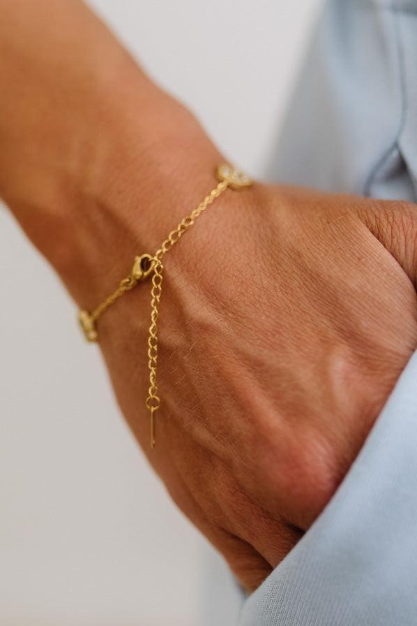Gold bracelet on a wrist with a blurred background