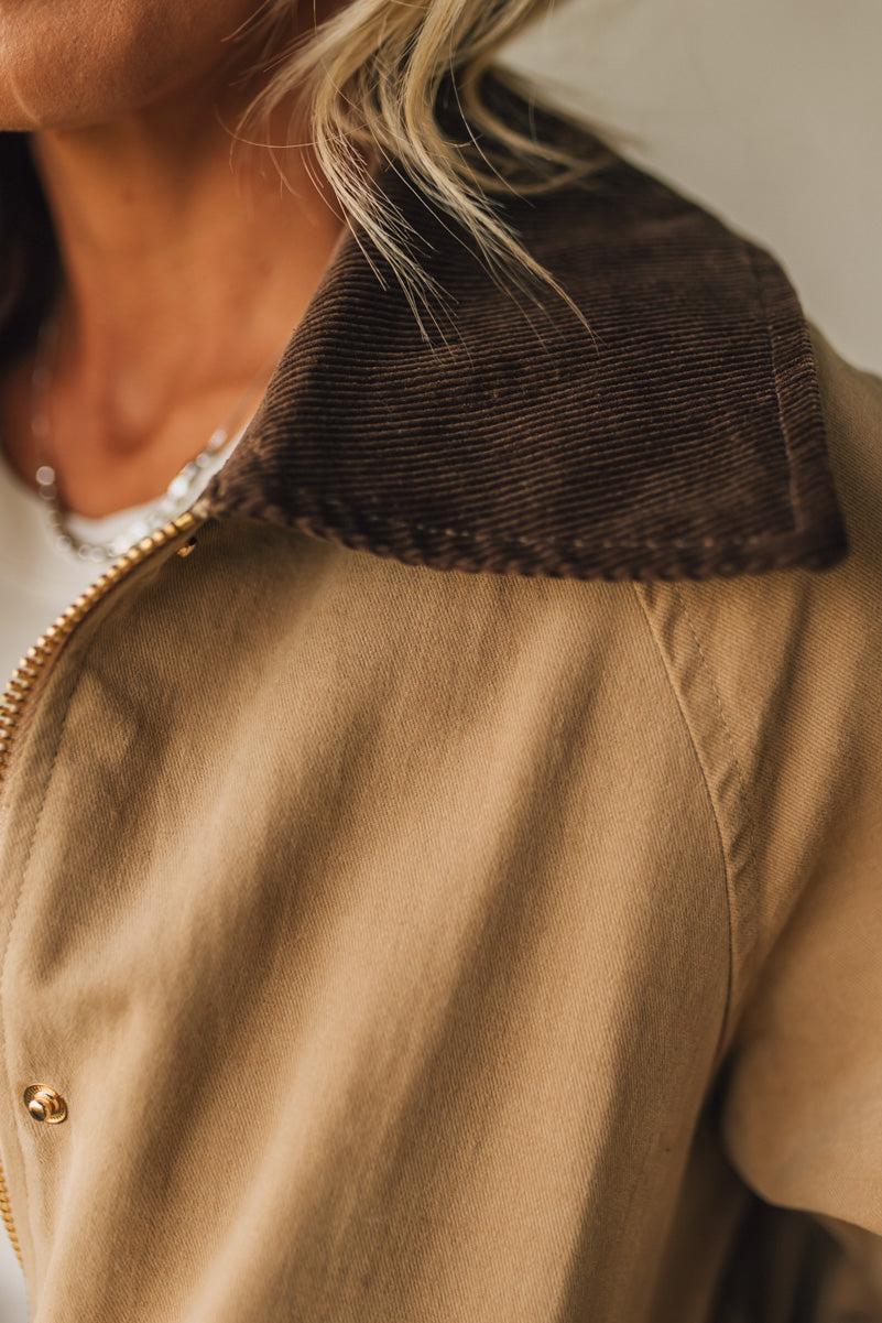 Close-up of a person wearing a brown jacket with a textured collar.