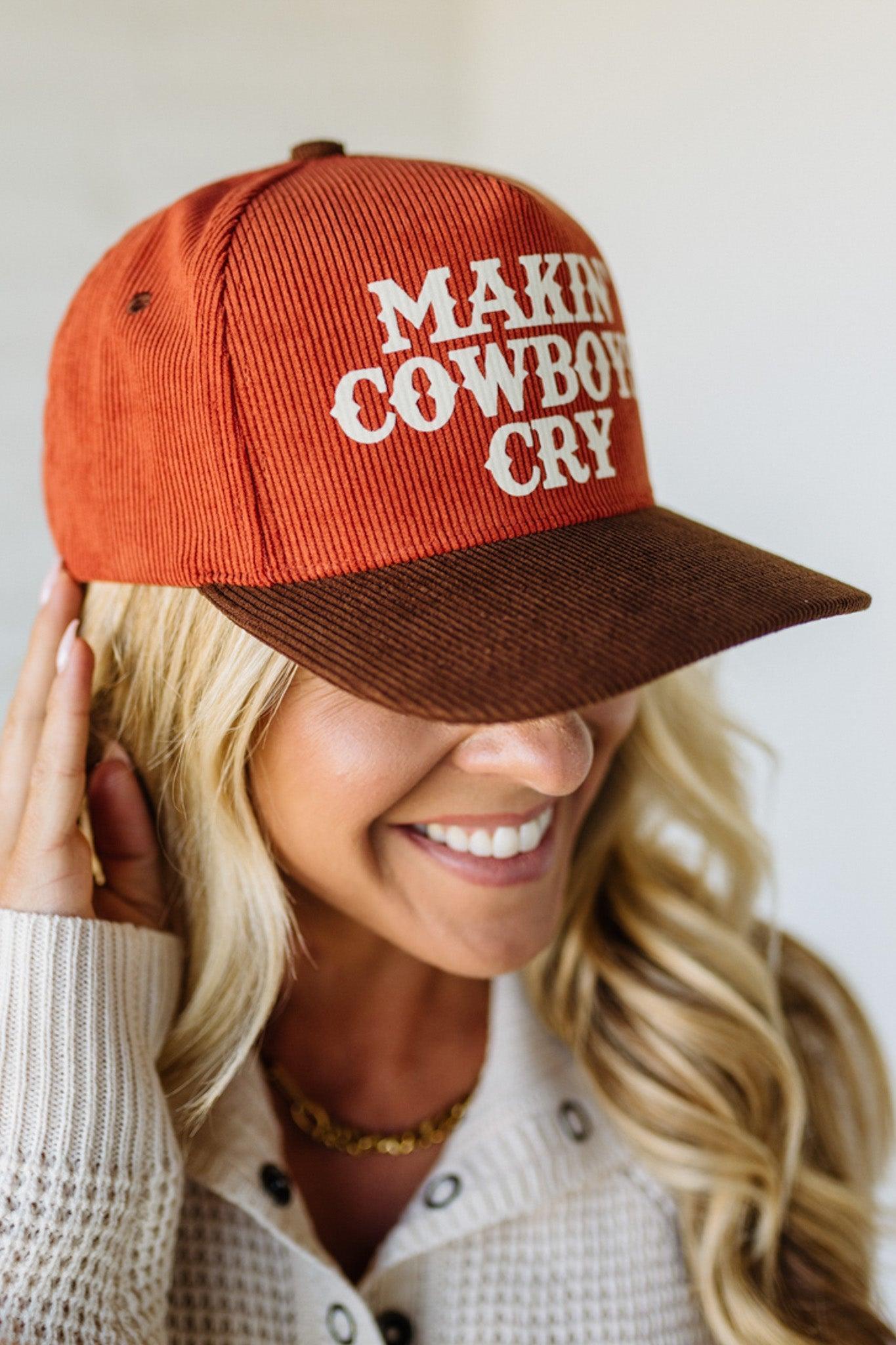 Person wearing a rust cap with "MAKIN' COWBOYS CRY" printed on it, against a plain background