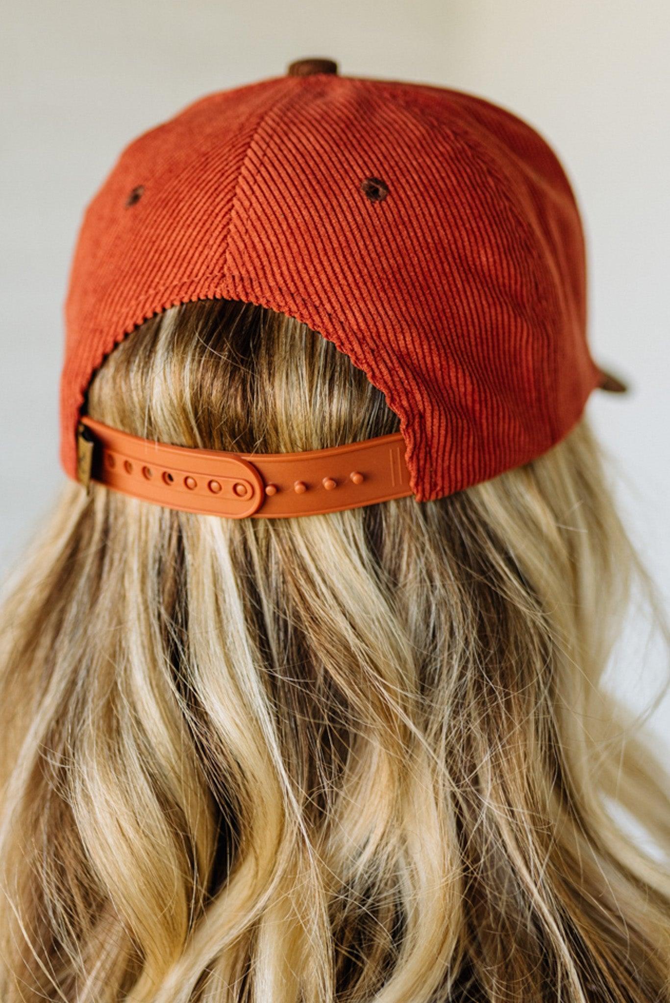 Person wearing an orange cap with a plain background