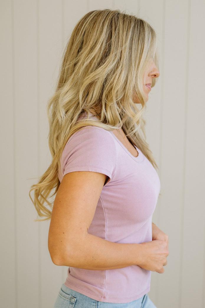 Woman wearing a light pink top against a beige background