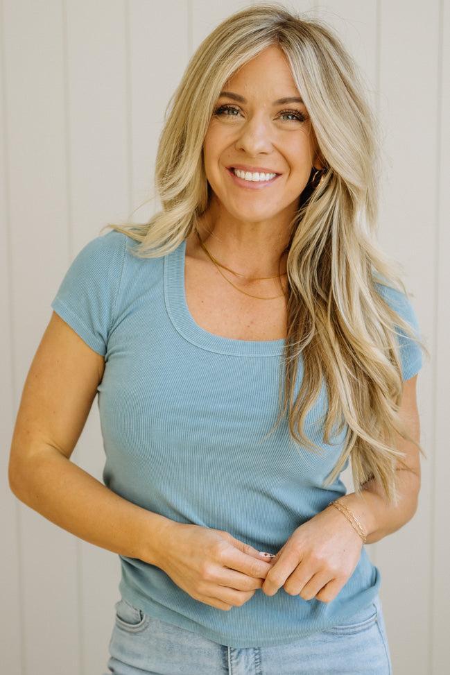 Woman wearing a blue top with a neutral background