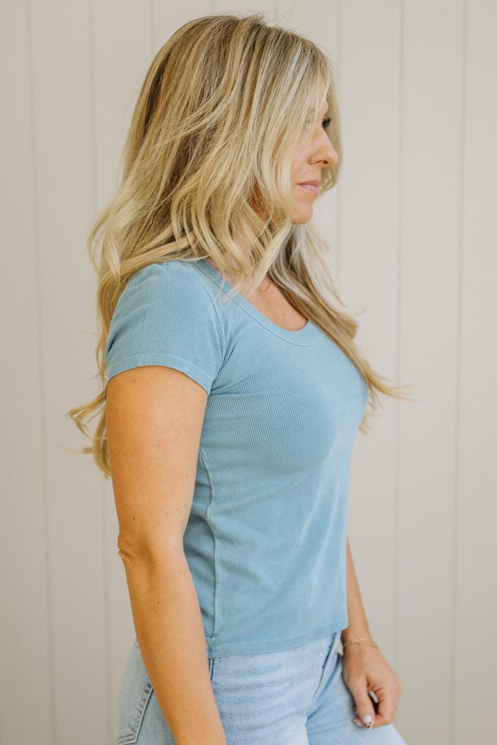 Woman wearing a light blue t-shirt against a neutral background