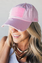 Blonde woman wearing a single color distressed american flag hat.