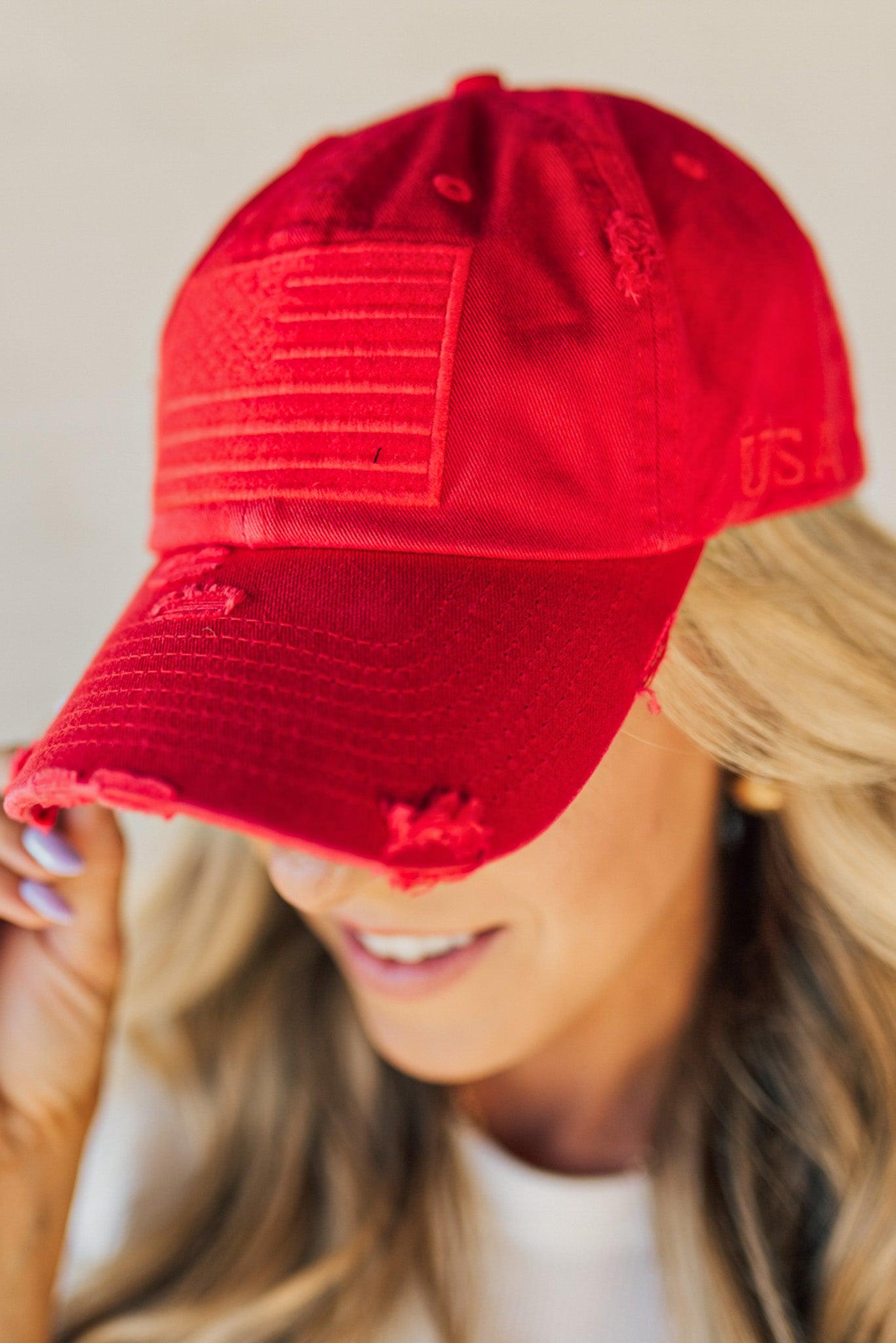 Blonde woman wearing a single color distressed american flag hat.