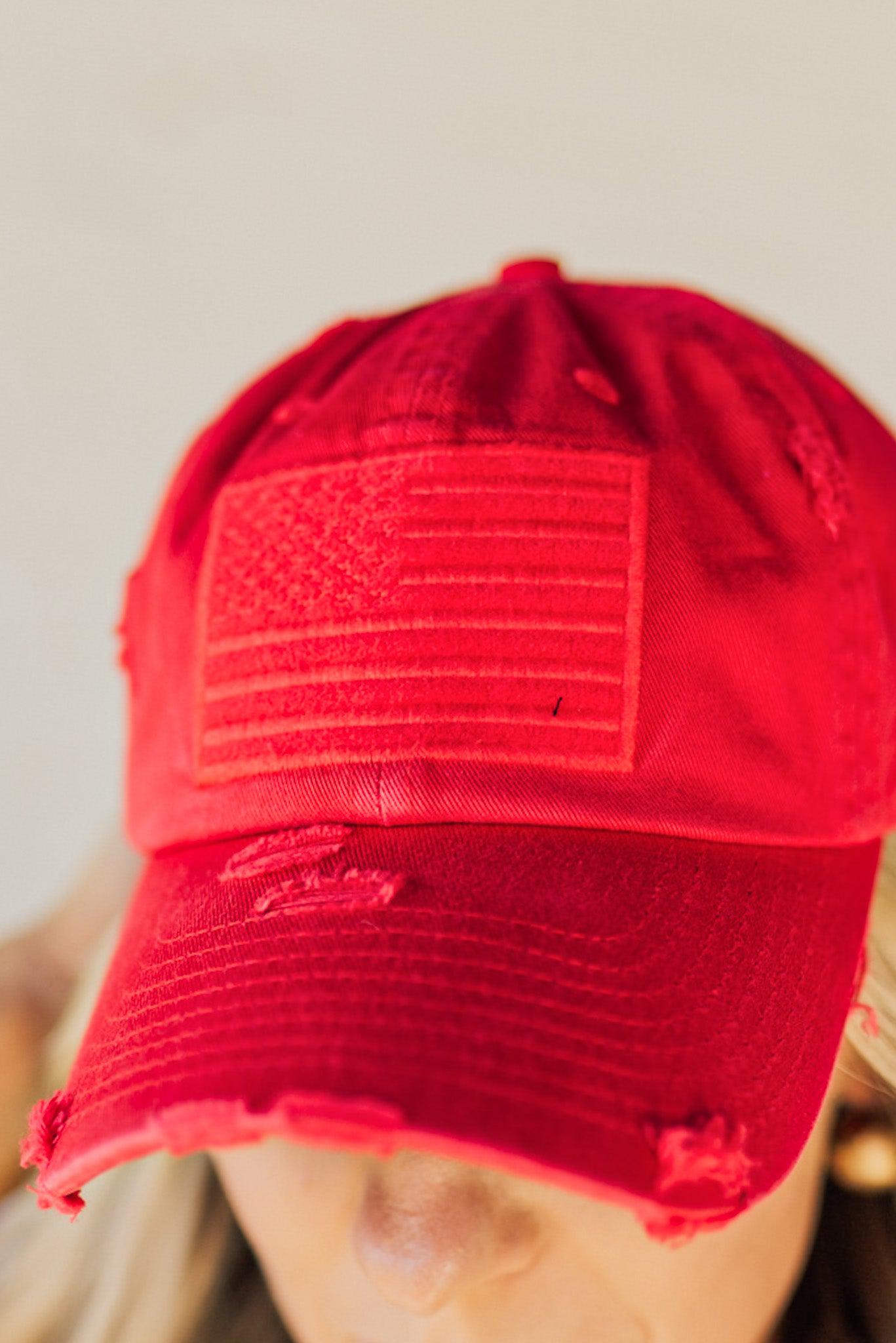 Blonde woman wearing a single color distressed american flag hat.