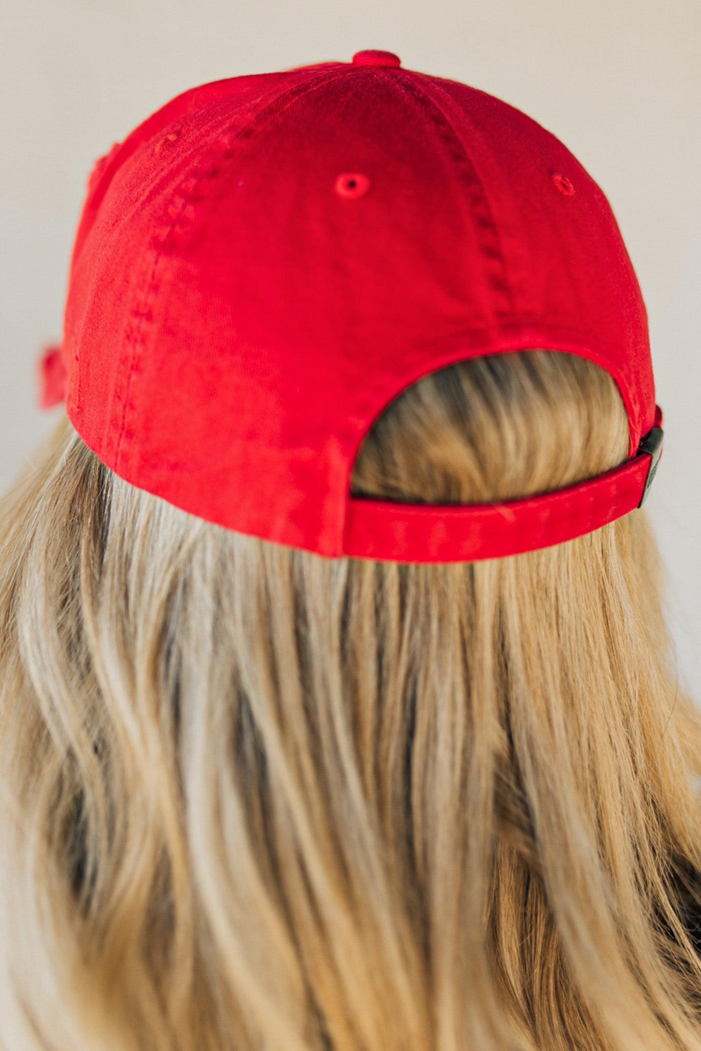 Blonde woman wearing a single color distressed american flag hat.