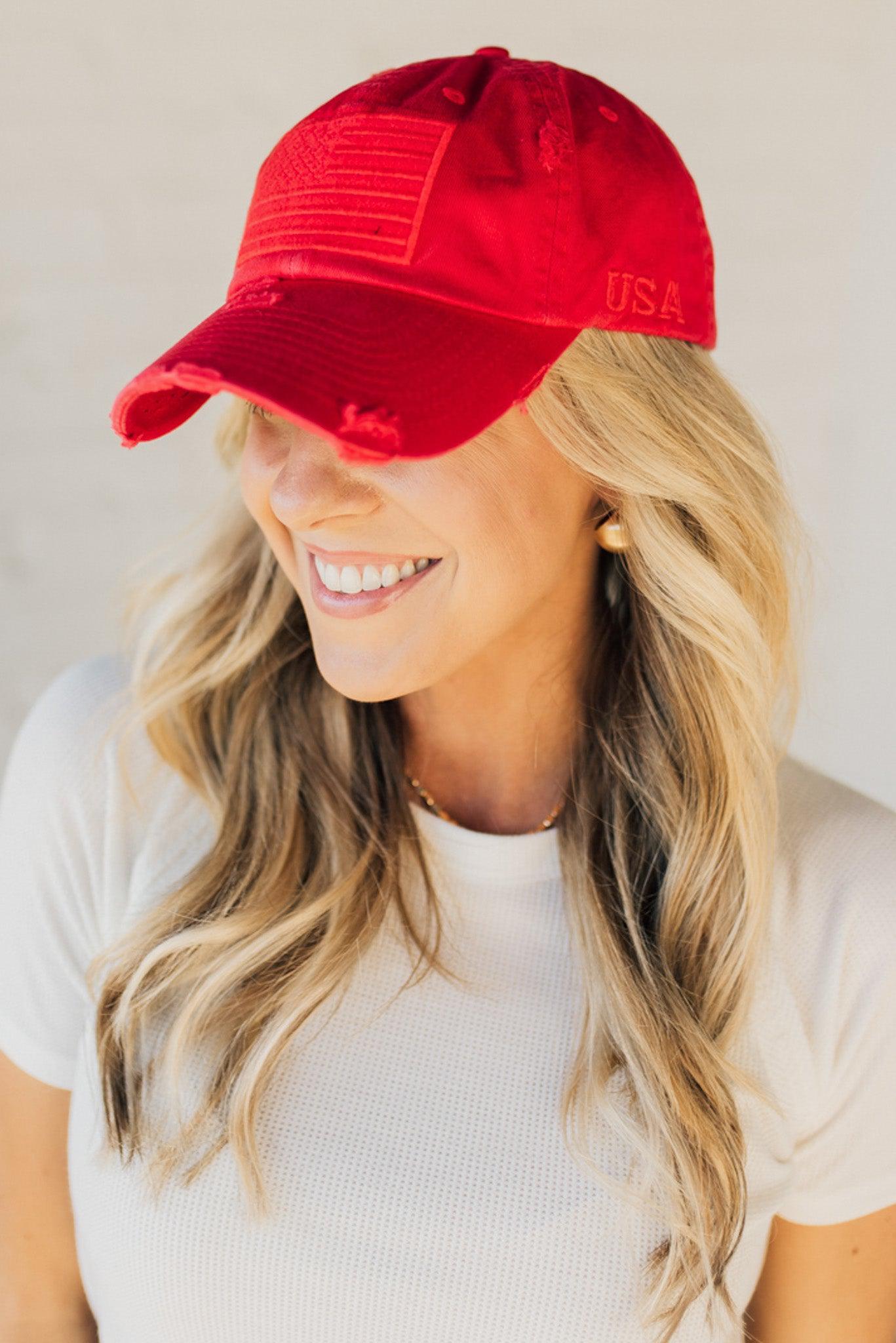 Blonde woman wearing a single color distressed american flag hat.