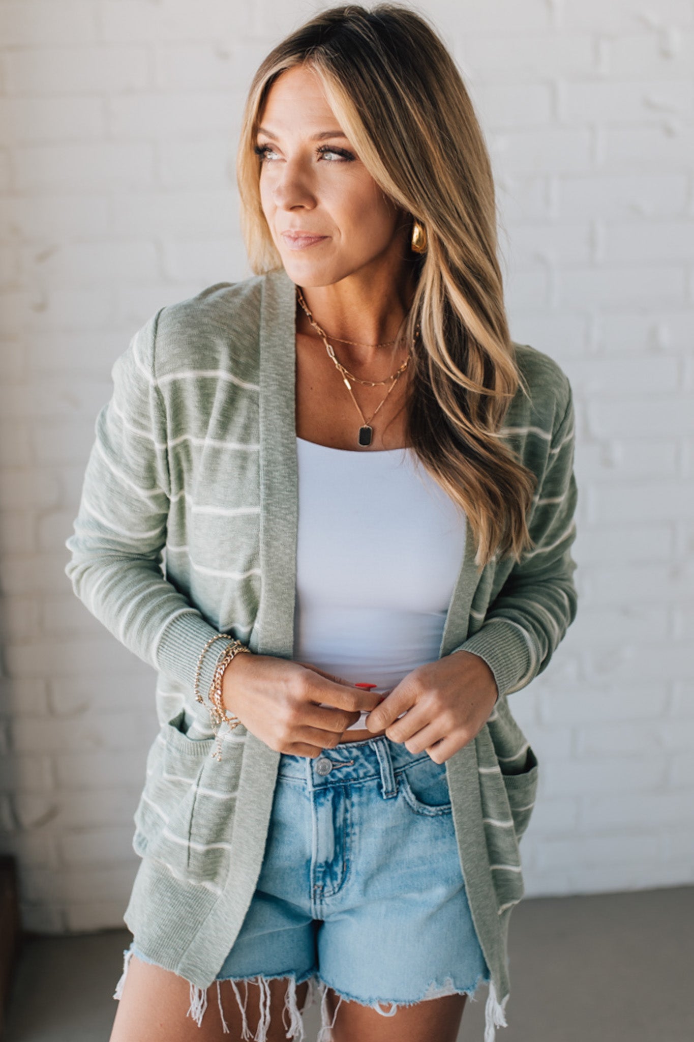 BLONDE WOMAN IN SHORTS WEARING A STRIPED COTTON SLUB CARDIGAN.