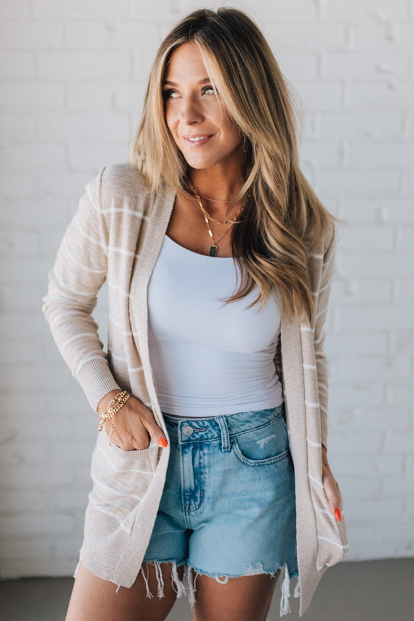 BLONDE WOMAN IN SHORTS WEARING A STRIPED COTTON SLUB CARDIGAN.