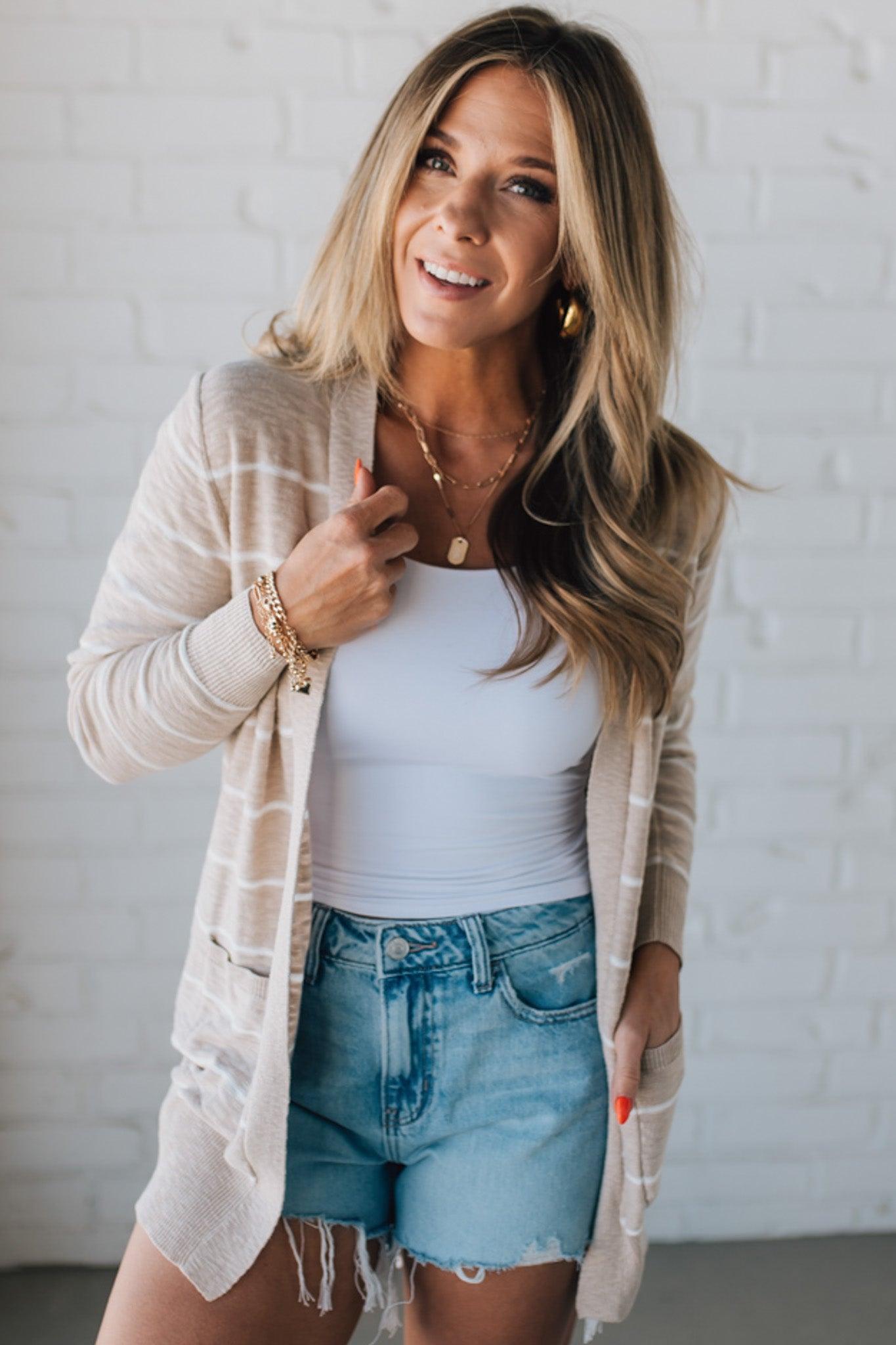 BLONDE WOMAN IN SHORTS WEARING A STRIPED COTTON SLUB CARDIGAN.