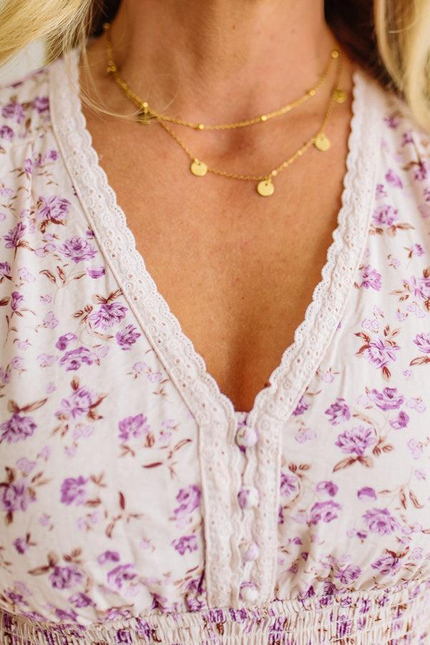 Woman wearing an 18K Gold Dipped Stainless Steel Layered Chain Necklace with small disc charms.