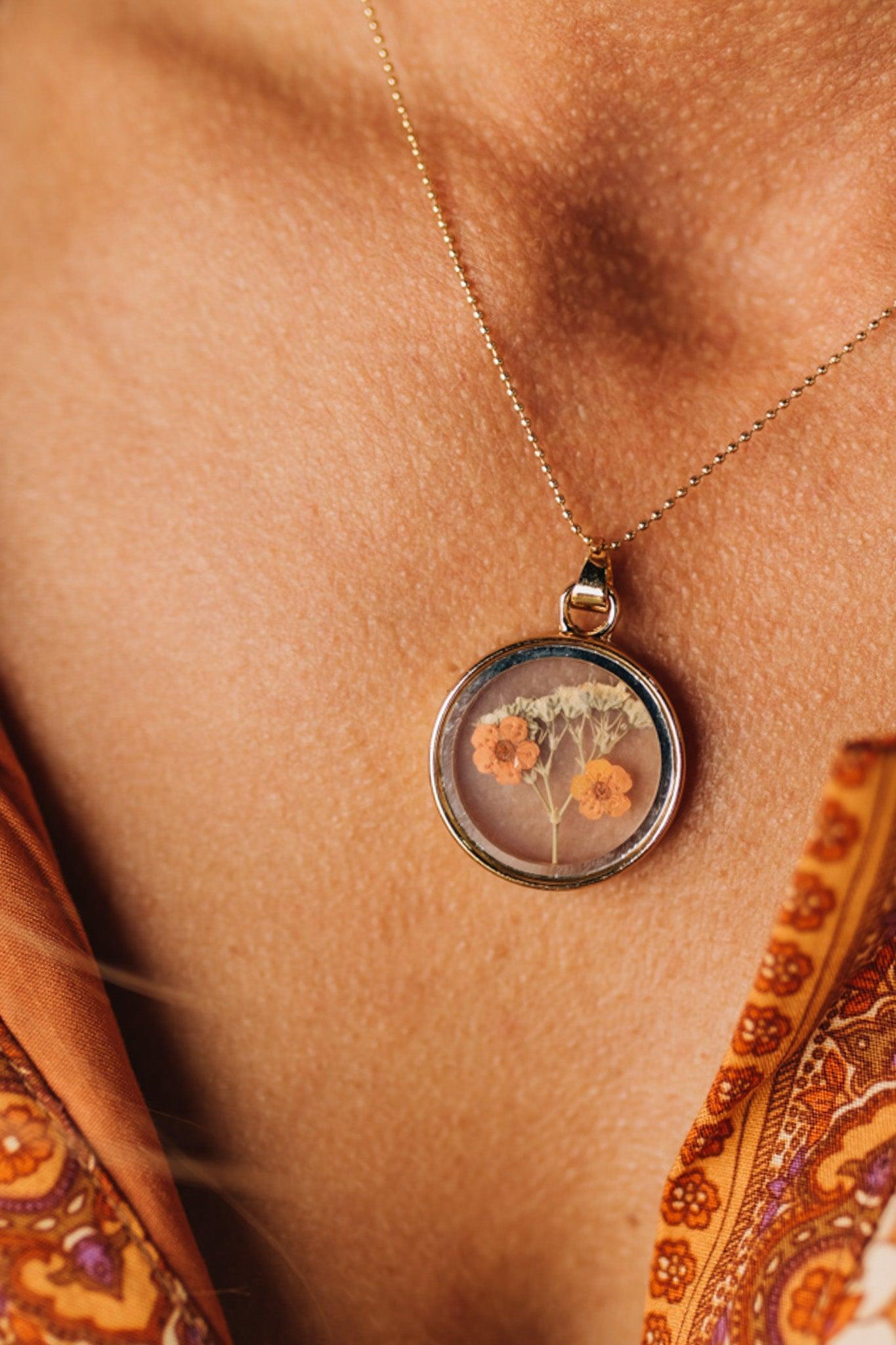 Double Sided Dry Flower Pendant Necklace with mini orange flowers inside.
