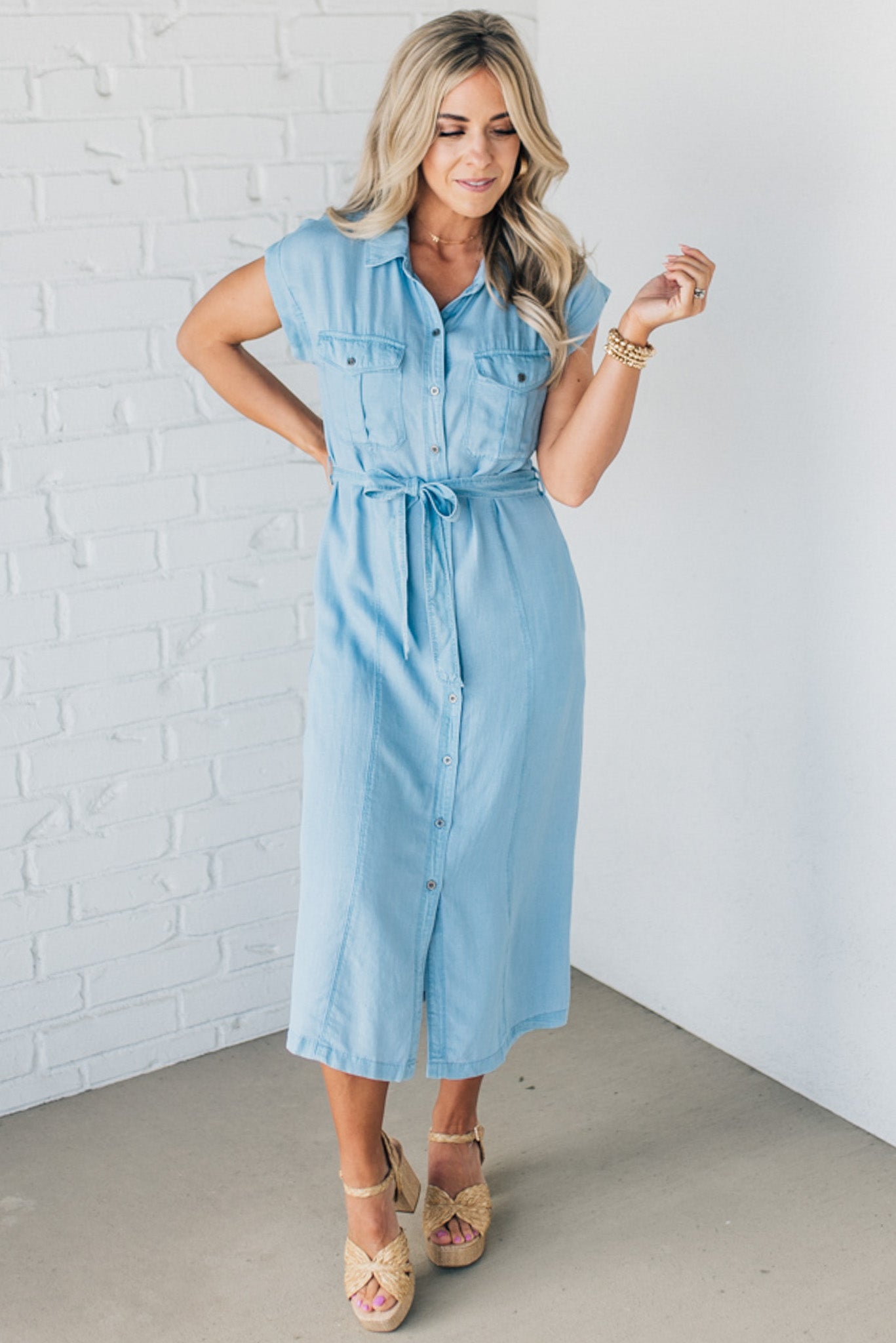 BLONDE WOMAN WEARING A BUTTON FRONT LIGHTWEIGHT TENCEL CHAMBRAY MIDI DRESS.