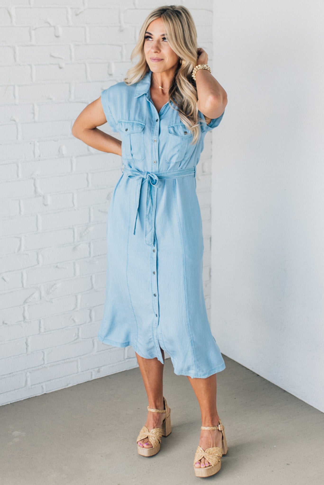 BLONDE WOMAN WEARING A BUTTON FRONT LIGHTWEIGHT TENCEL CHAMBRAY MIDI DRESS.