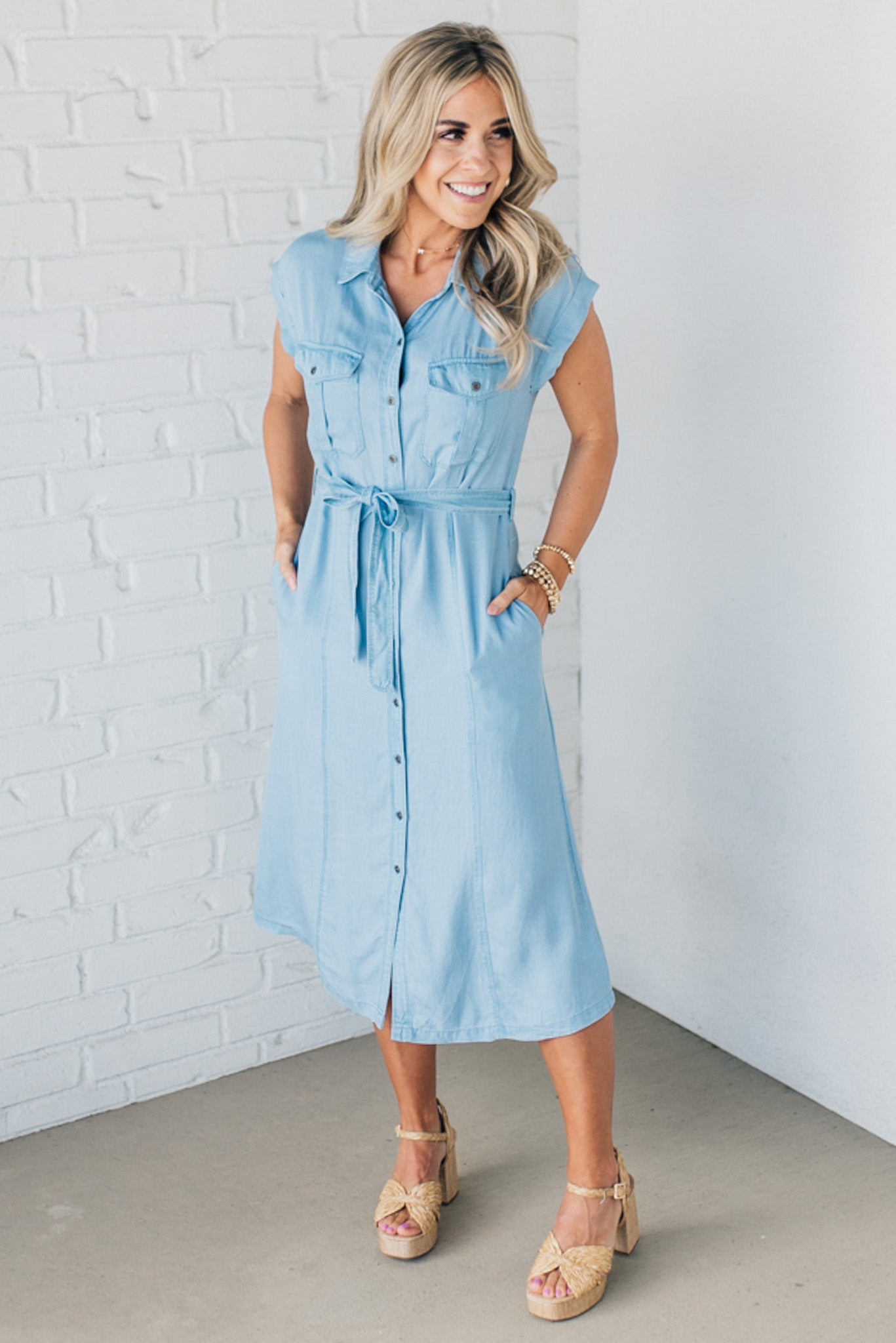 BLONDE WOMAN WEARING A BUTTON FRONT LIGHTWEIGHT TENCEL CHAMBRAY MIDI DRESS.