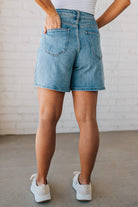 WOMAN WEARING STRETCH BLEND HIGH WAIST BERMUDA DENIM MOM SHORTS.