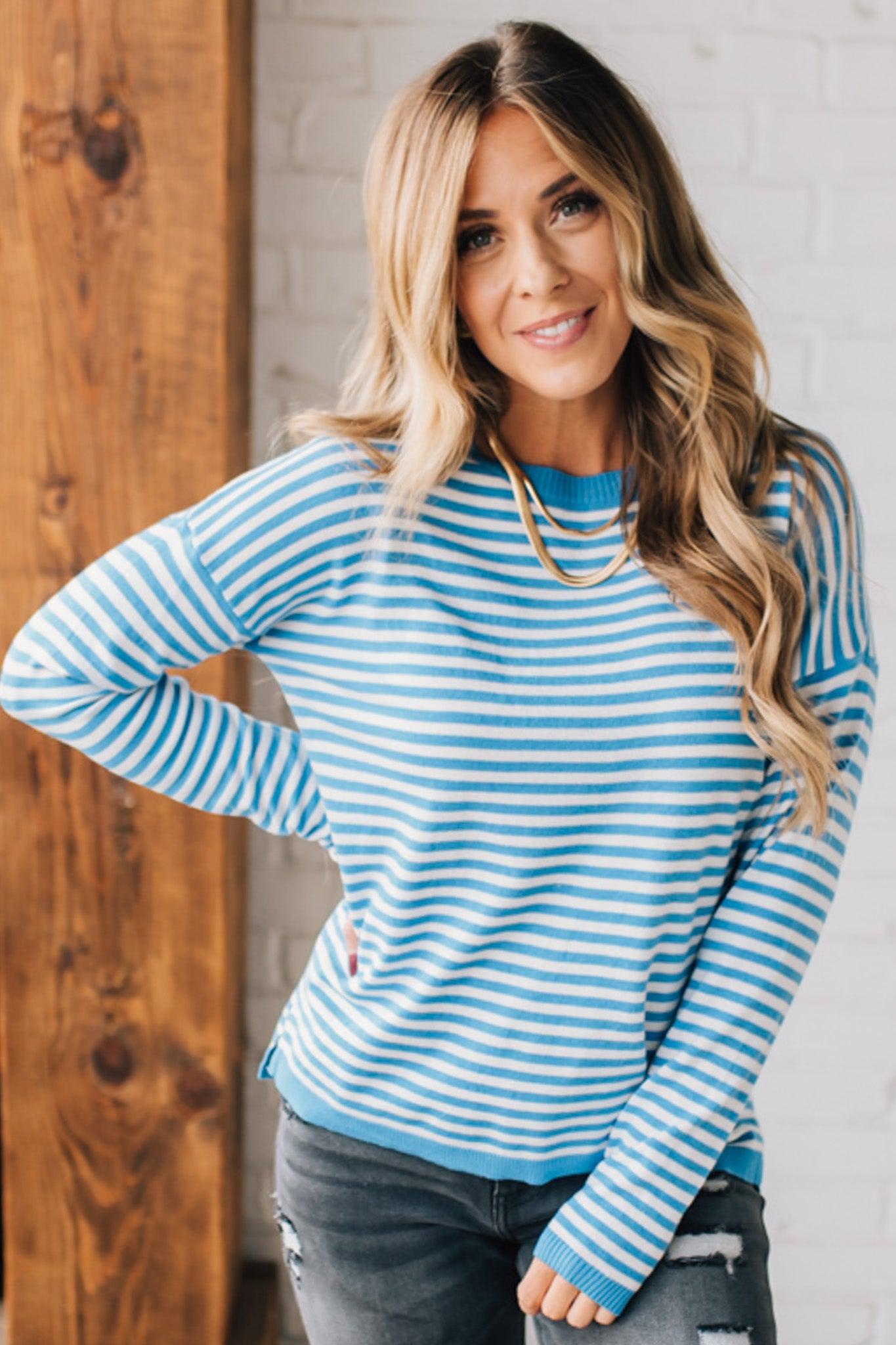 BLONDE WOMAN MODELING A LONG SLEEVE STRIPED LIGHTWEIGHT SWEATER WITH RIBBED SOLID COLORED NECKLINE AND SLEEVE CUFFS