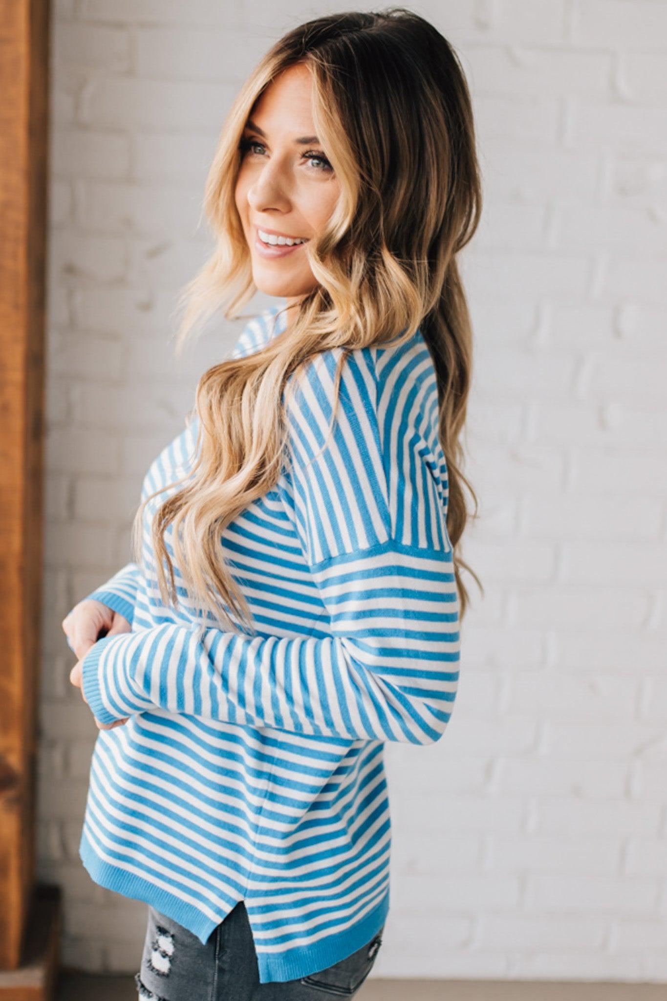 BLONDE WOMAN MODELING A LONG SLEEVE STRIPED LIGHTWEIGHT SWEATER WITH RIBBED SOLID COLORED NECKLINE AND SLEEVE CUFFS