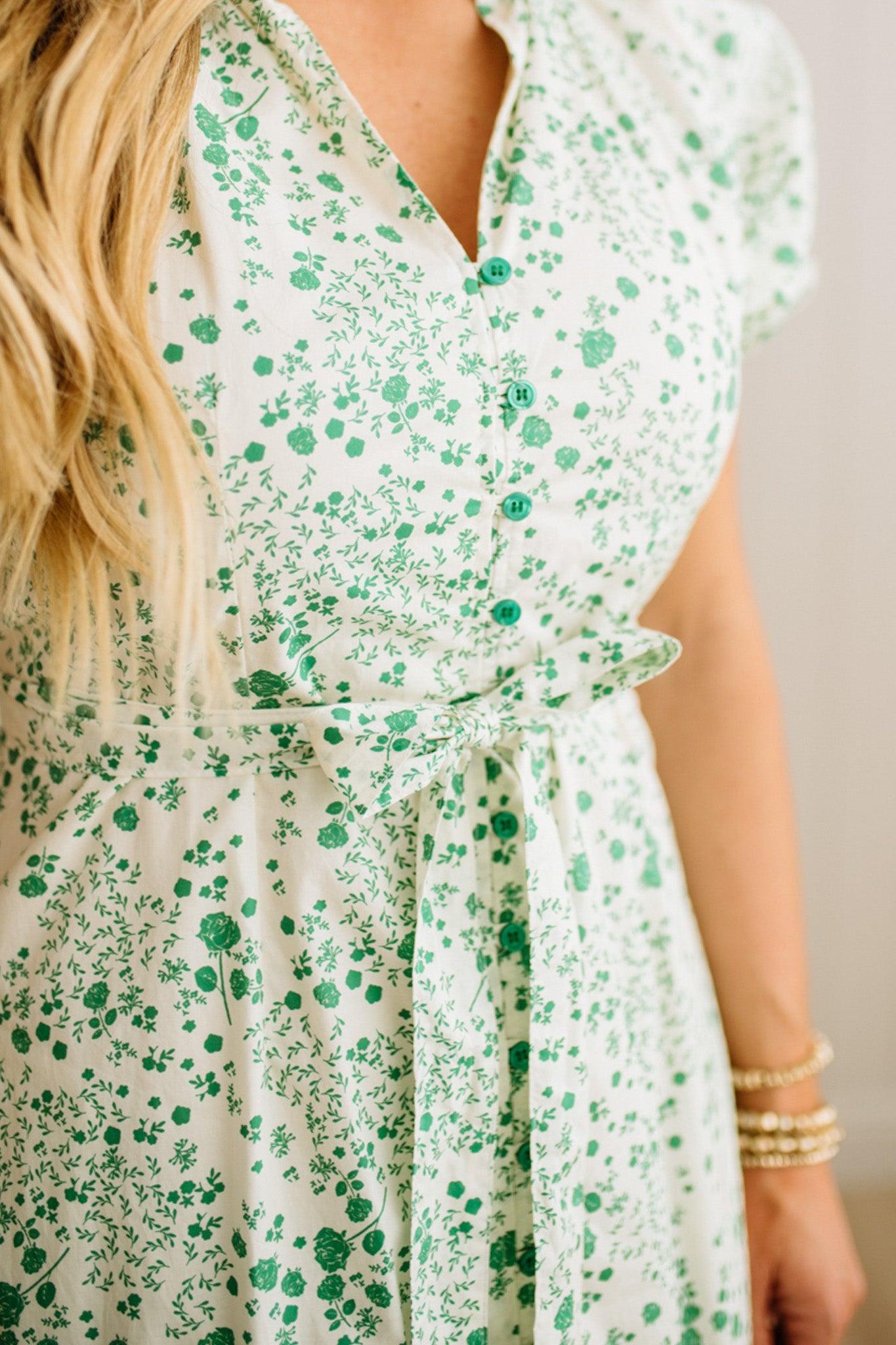 Green floral dress worn by a person with a neutral background