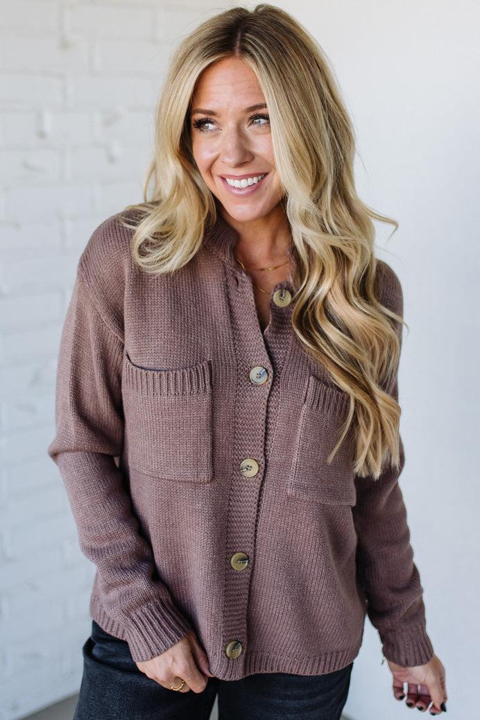 Woman wearing a brown cardigan against a white background