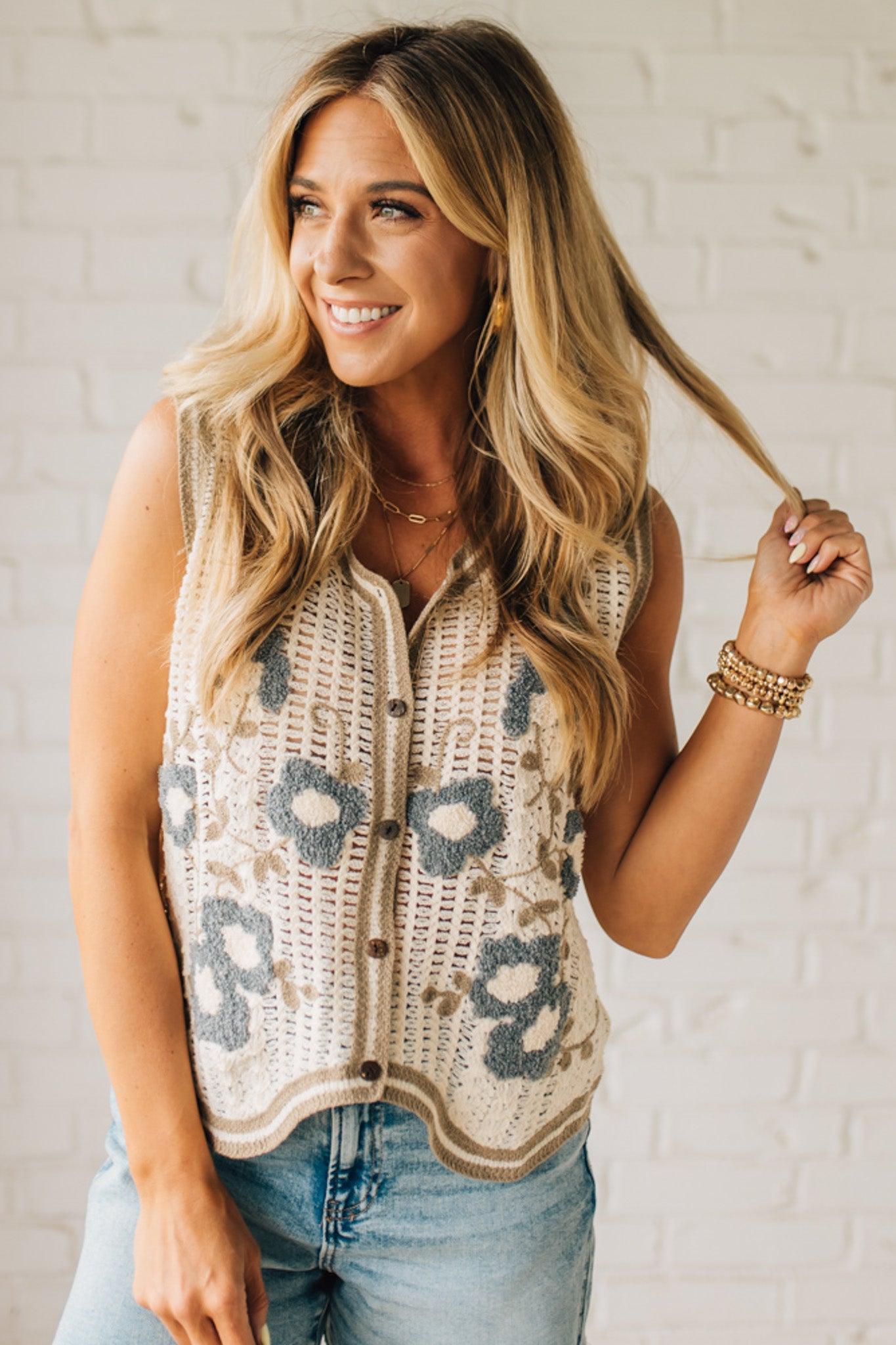 Blonde woman wearing a Floral Embroidery Patch Crochet Sweater Vest in cream, with mocha and dusty blue weave.