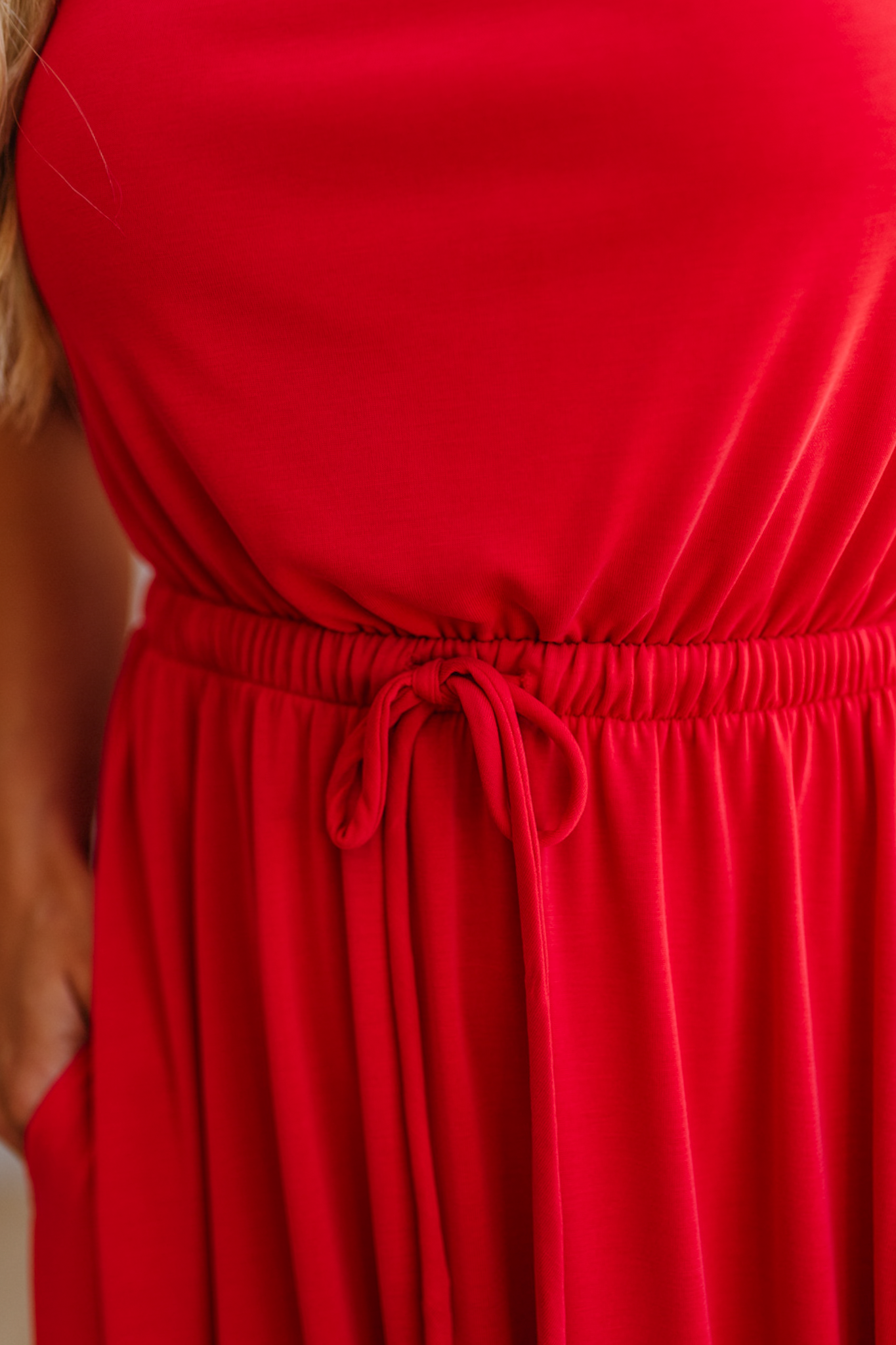 Close-up of a red dress with a tie waist.